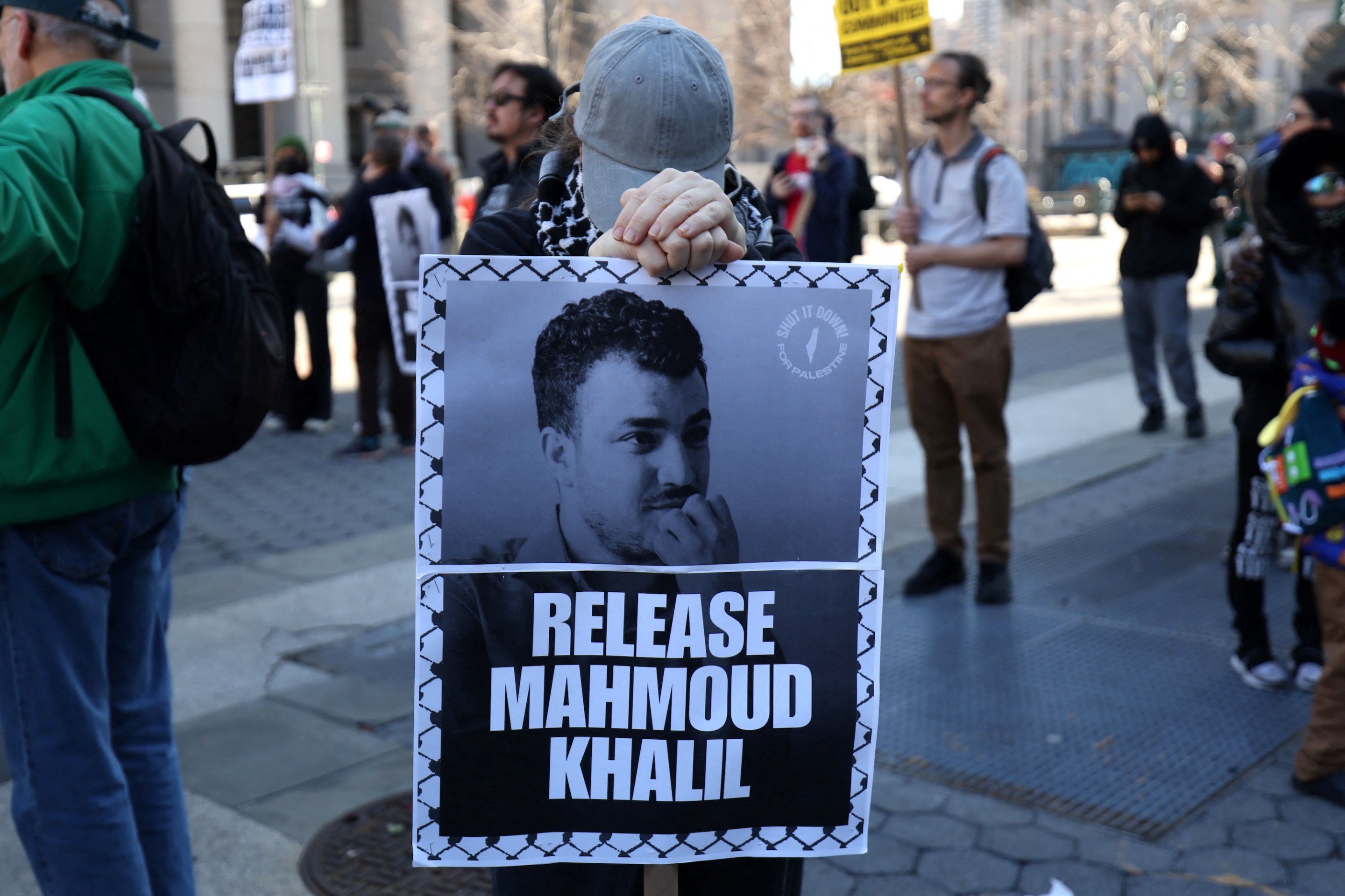 A protestor with a sign that reads "Release Mahmoud Khalil."