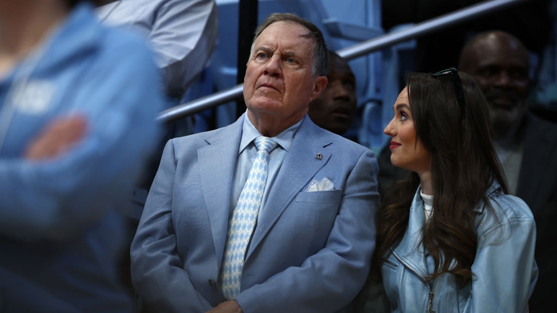 North Carolina Tar Heels football head coach Bill Belichick and his girlfriend Jordon Hudson look on during the first half of the game between the North Carolina Tar Heels and the Duke Blue Devils at Dean E. Smith Center on March 08, 2025 in Chapel Hill, North Carolina.