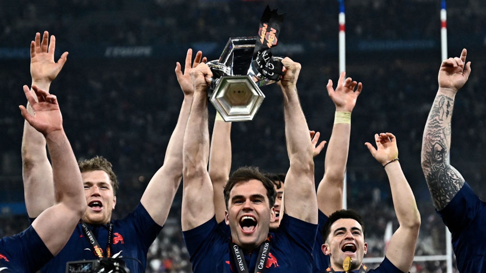 France's wing Damian Penaud (C) holds the trophy while France's players celebrate winning the Six Nations international rugby union tournament at the end of their match against Scotland, at Stade de France in Saint-Denis, Paris' suburb, on March 15, 2025.
