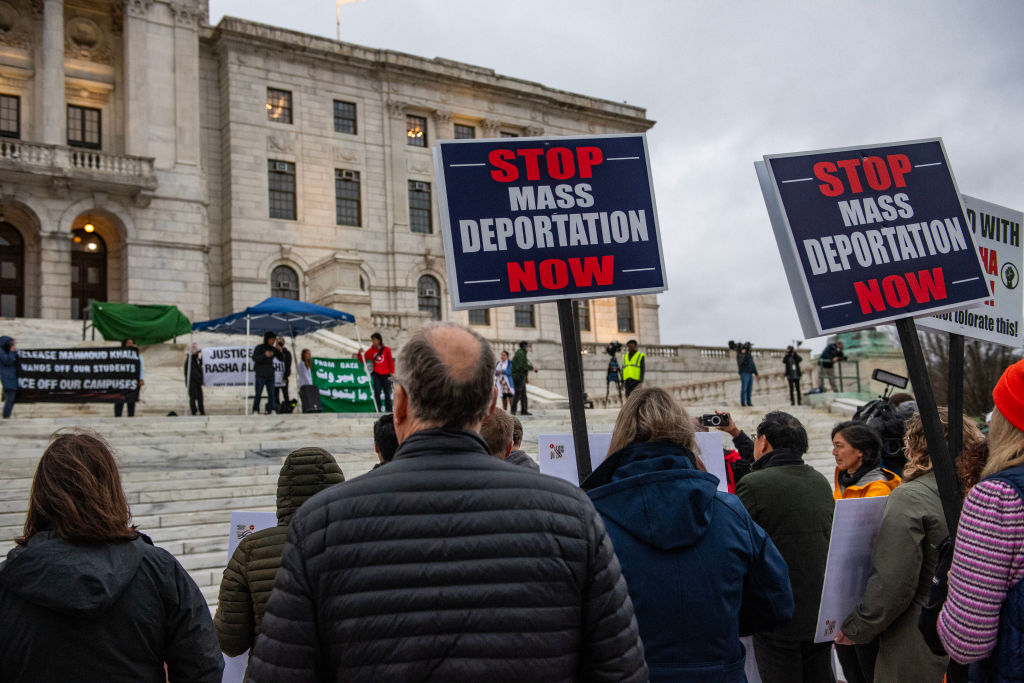 Demonstrators hold signs as they protest the deportation of Assistant Professor of Medicine Dr. Rasha Alawieh of Brown University at the State House in Providence, Rhode Island
