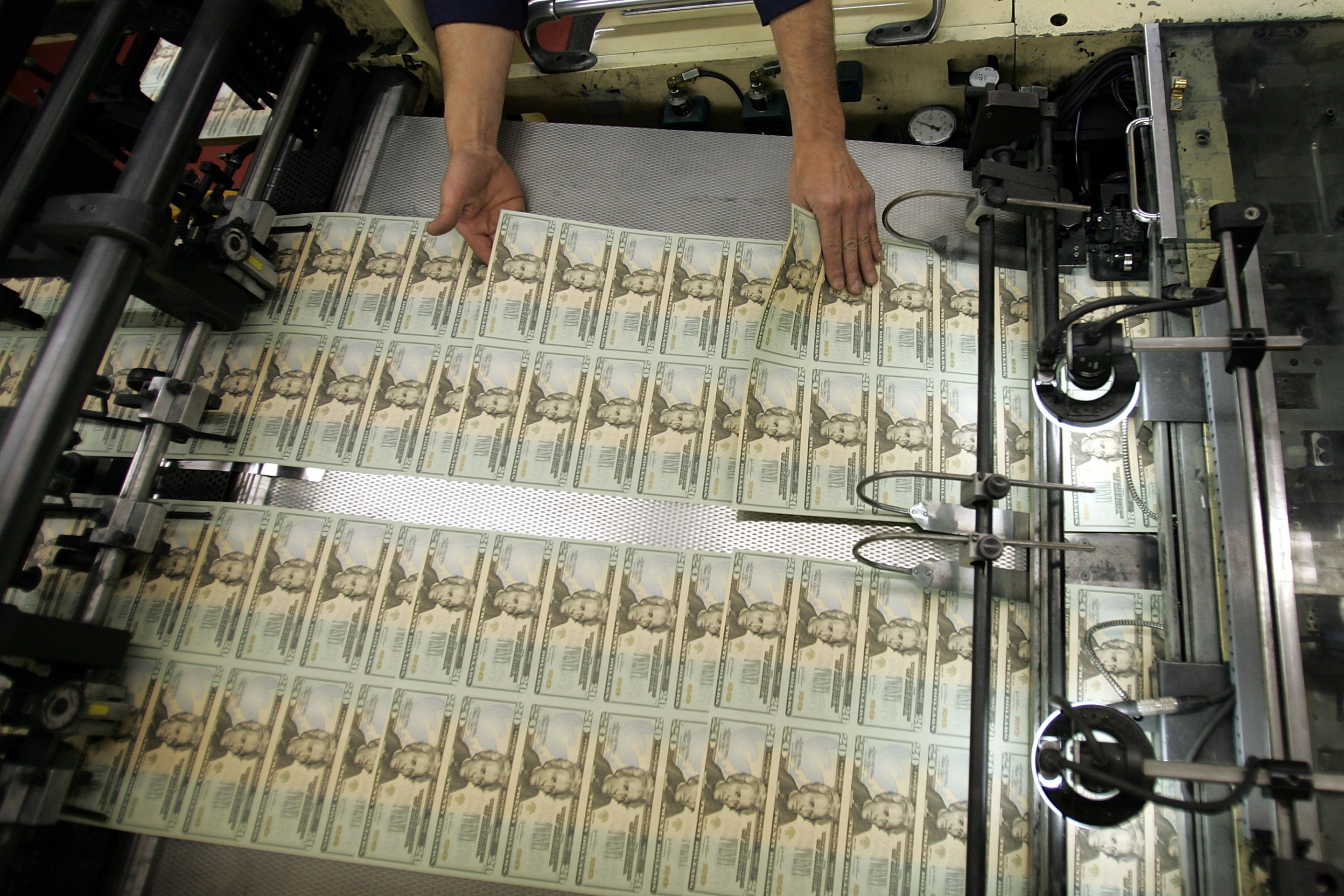 WASHINGTON - APRIL 20: A worker looks for defective bills in the sheets of newly printed twenty dollar bills as they are prepared for distribution to financial institutions April 20, 2005 at the Department of the Treasury Bureau of Engraving and Printing in Washington, DC. Regardless of its denomination, a bill, or banknote, costs 6 cents to produce. A dollar bill lasts about 22 months. (Photo by Joe Raedle/Getty Images)