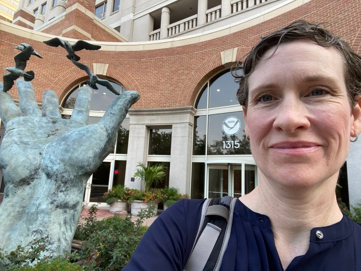 Sarah Cooley, the former director of NOAA's ocean acidification program, standing outside a NOAA office on her first day of work