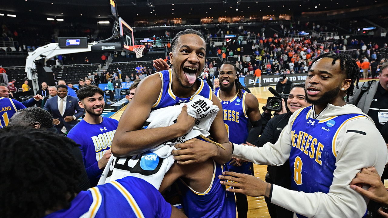 PROVIDENCE, RHODE ISLAND - MARCH 20: The McNeese Cowboys celebrate their win over the Clemson University Tigers during the first round of the 2025 NCAA Men's Basketball Tournament held at Amica Mutual Pavillion on March 20, 2025 in Providence, Rhode Island. A player is sticking his tongue out while being mobbed by teammates.