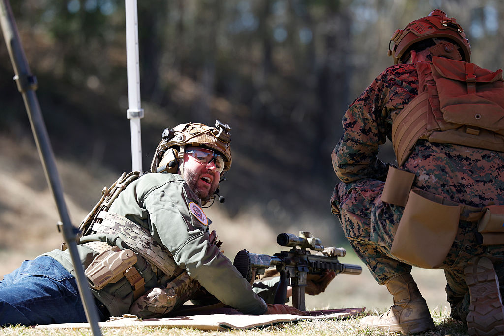U.S. Vice President JD Vance (L) shoots with U.S. Marines at a gun range during a visit to Marine Corps Base Quantico