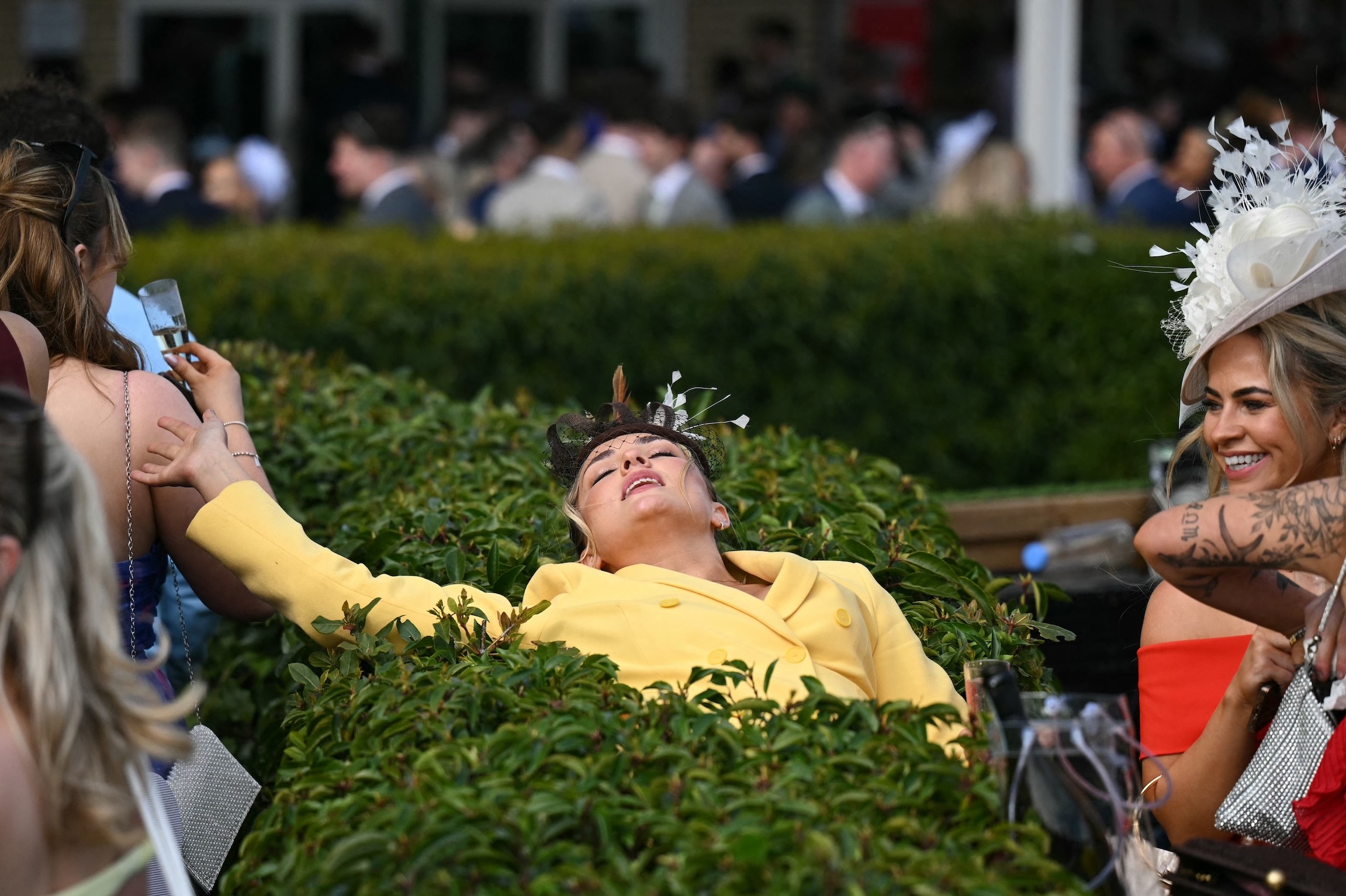 A racegoer relaxes on day two of the Grand National Festival horse race meeting at Aintree Racecourse in Liverpool, north-west England, on April 4, 2025. (Photo by Oli SCARFF / AFP)