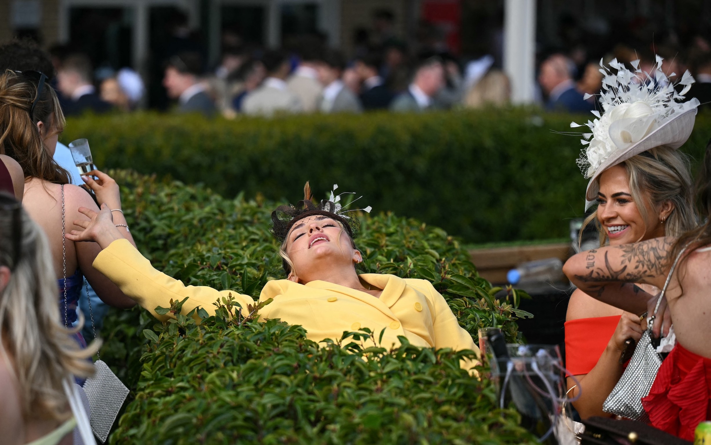 A racegoer relaxes on day two of the Grand National Festival horse race meeting at Aintree Racecourse in Liverpool, north-west England, on April 4, 2025. (Photo by Oli SCARFF / AFP)