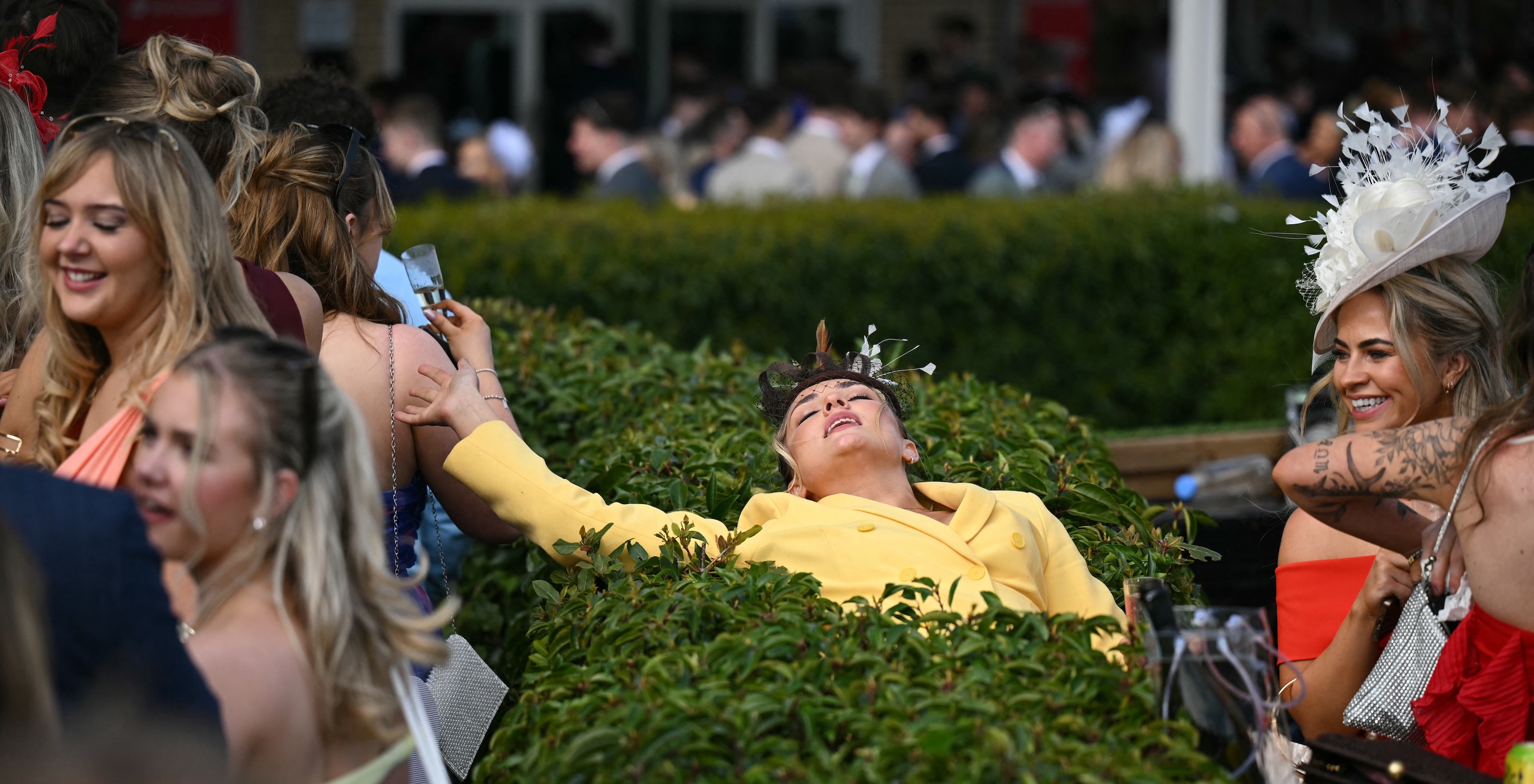 A racegoer relaxes on day two of the Grand National Festival horse race meeting at Aintree Racecourse in Liverpool, north-west England, on April 4, 2025. (Photo by Oli SCARFF / AFP)