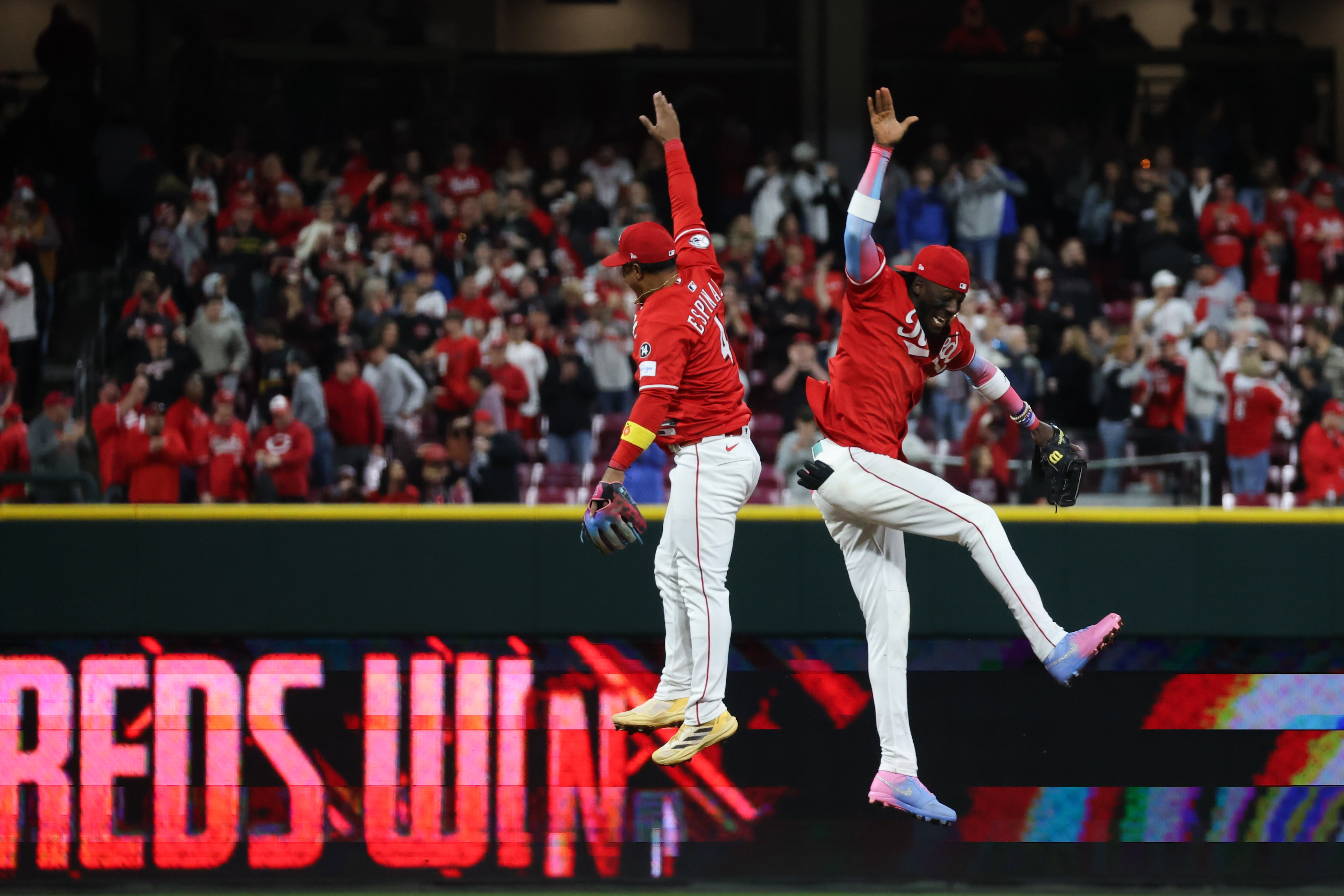 Santiago Espinal #4 and Elly De La Cruz #44 of the Cincinnati Reds celebrate after winning the game between the Pittsburgh Pirates and the Cincinnati Reds at Great American Ball Park on Saturday, April 12, 2025 in Cincinnati, Ohio.