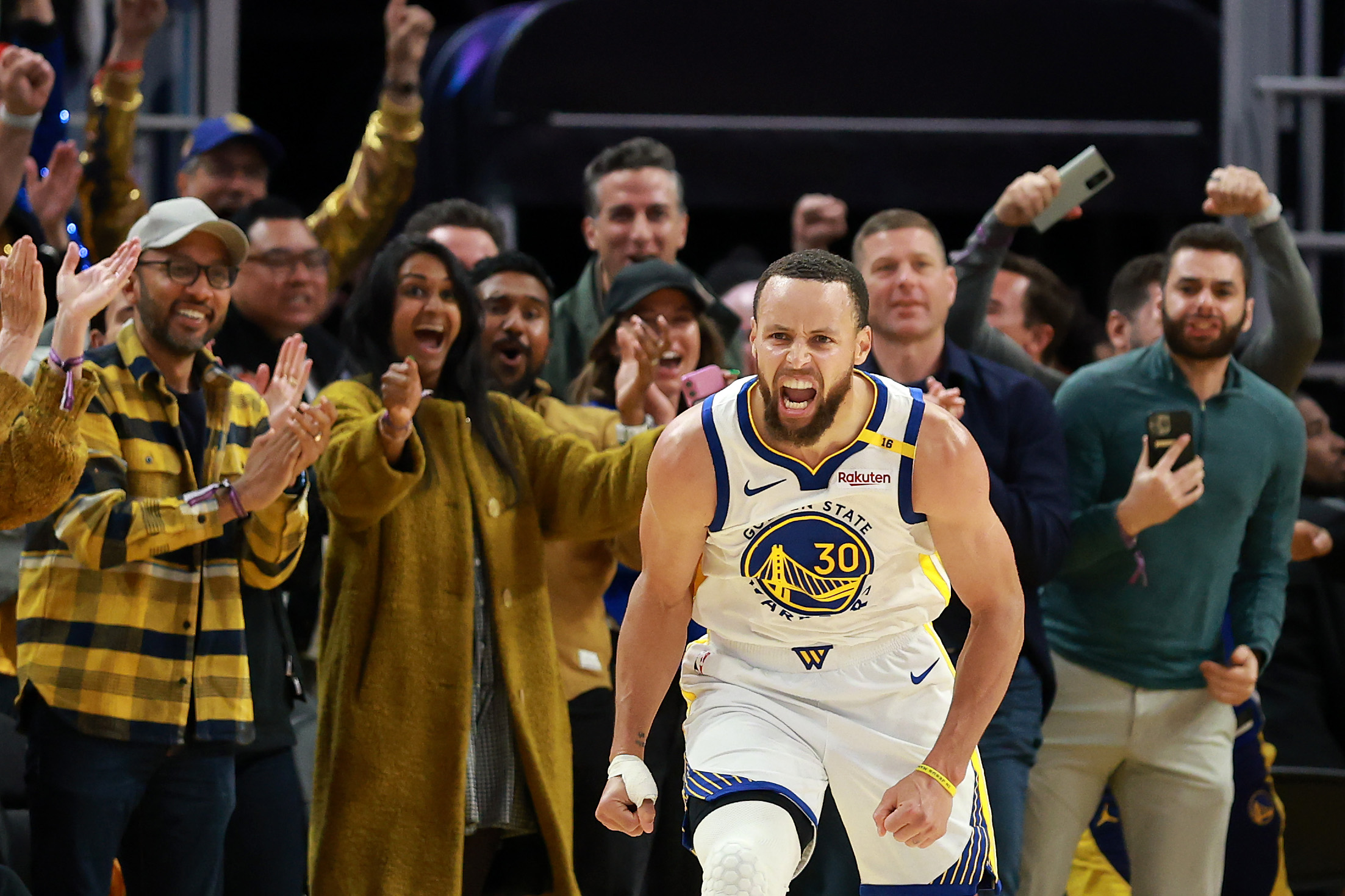 Stephen Curry of the Golden State Warriors reacts after making a basket against the Memphis Grizzlies in the second half of the NBA play-in tournament game at Chase Center on April 15, 2025.