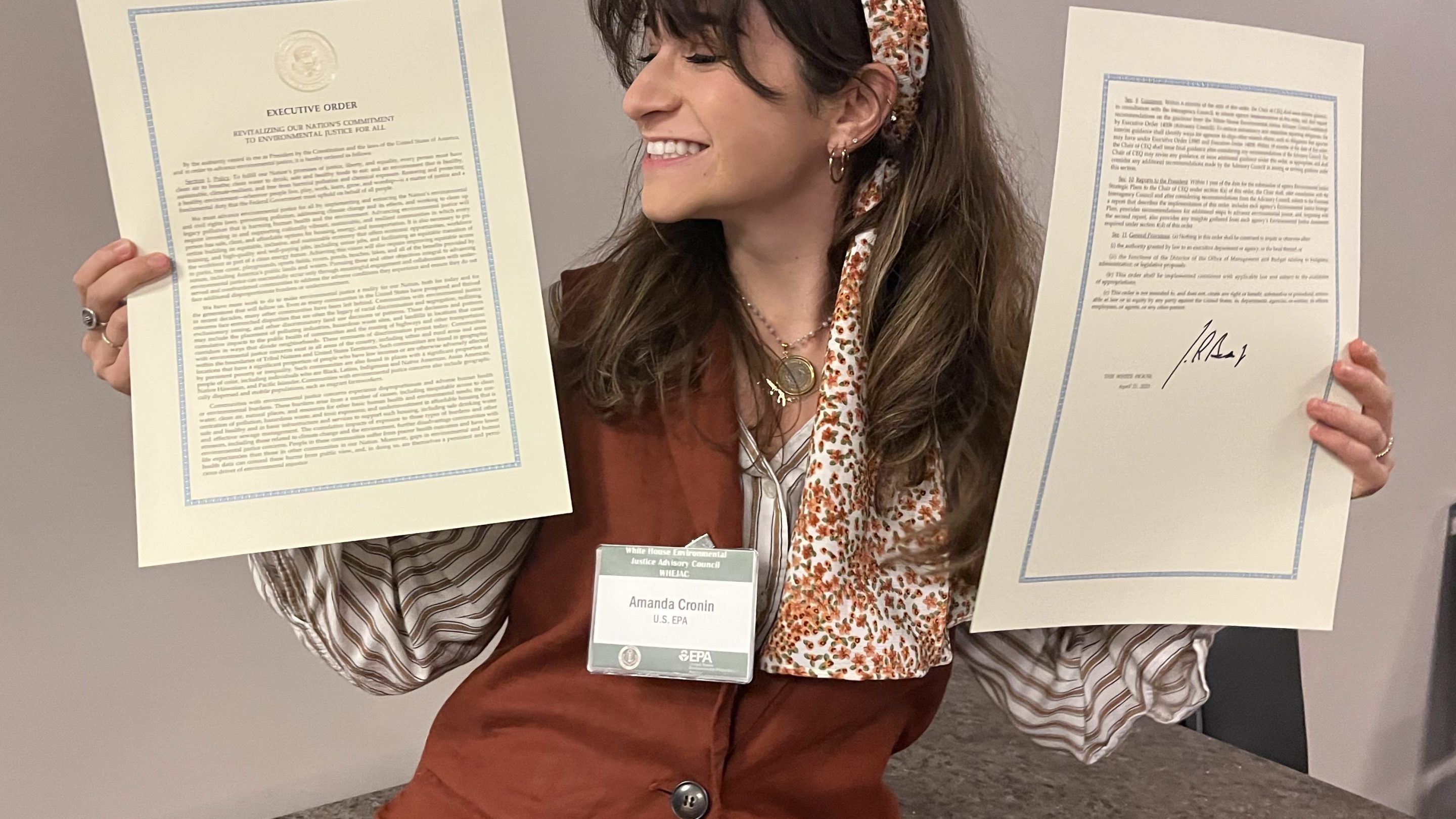 A photo of fired EPA program analyst Amanda Cronin holding the text of Executive Order 14096