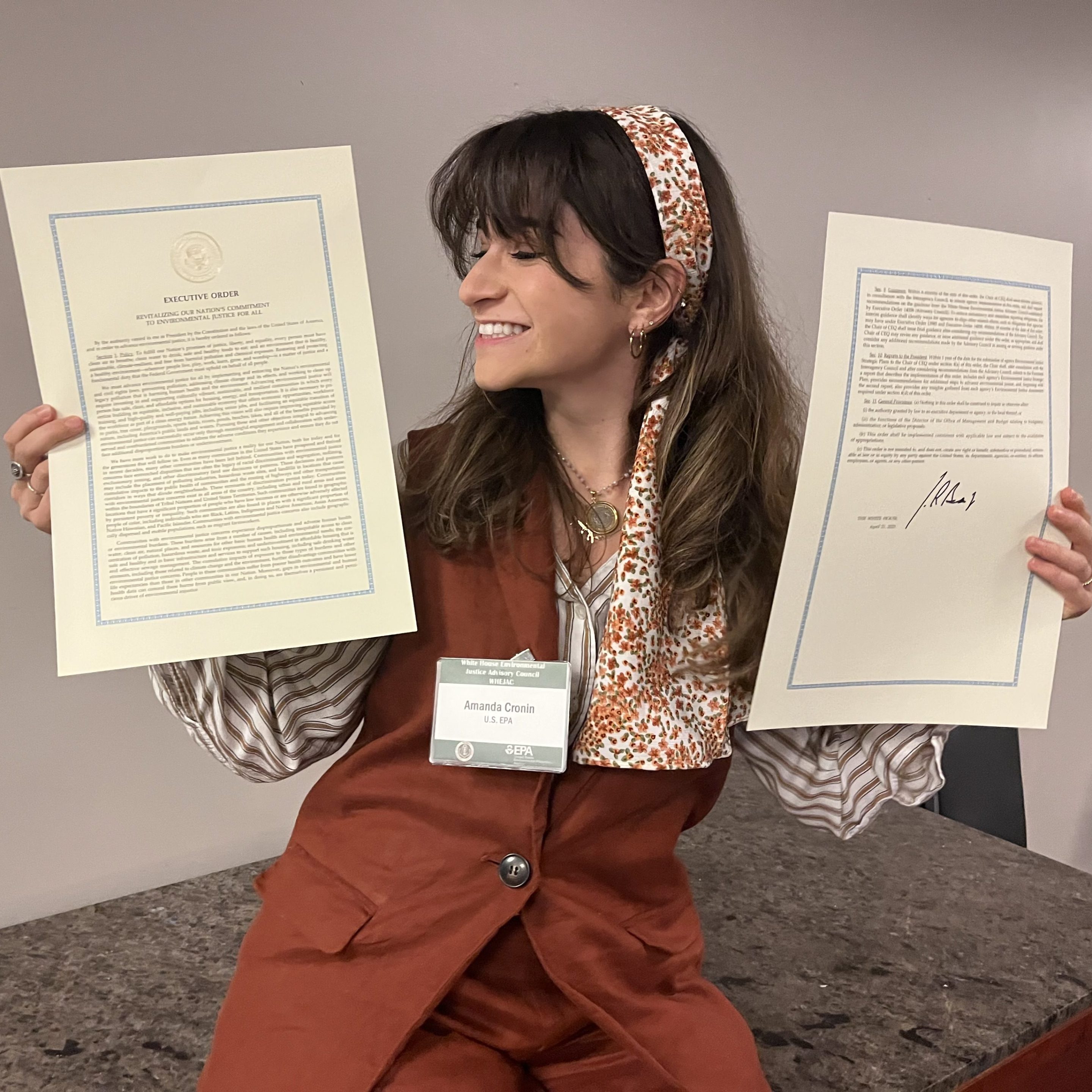 A photo of fired EPA program analyst Amanda Cronin holding the text of Executive Order 14096