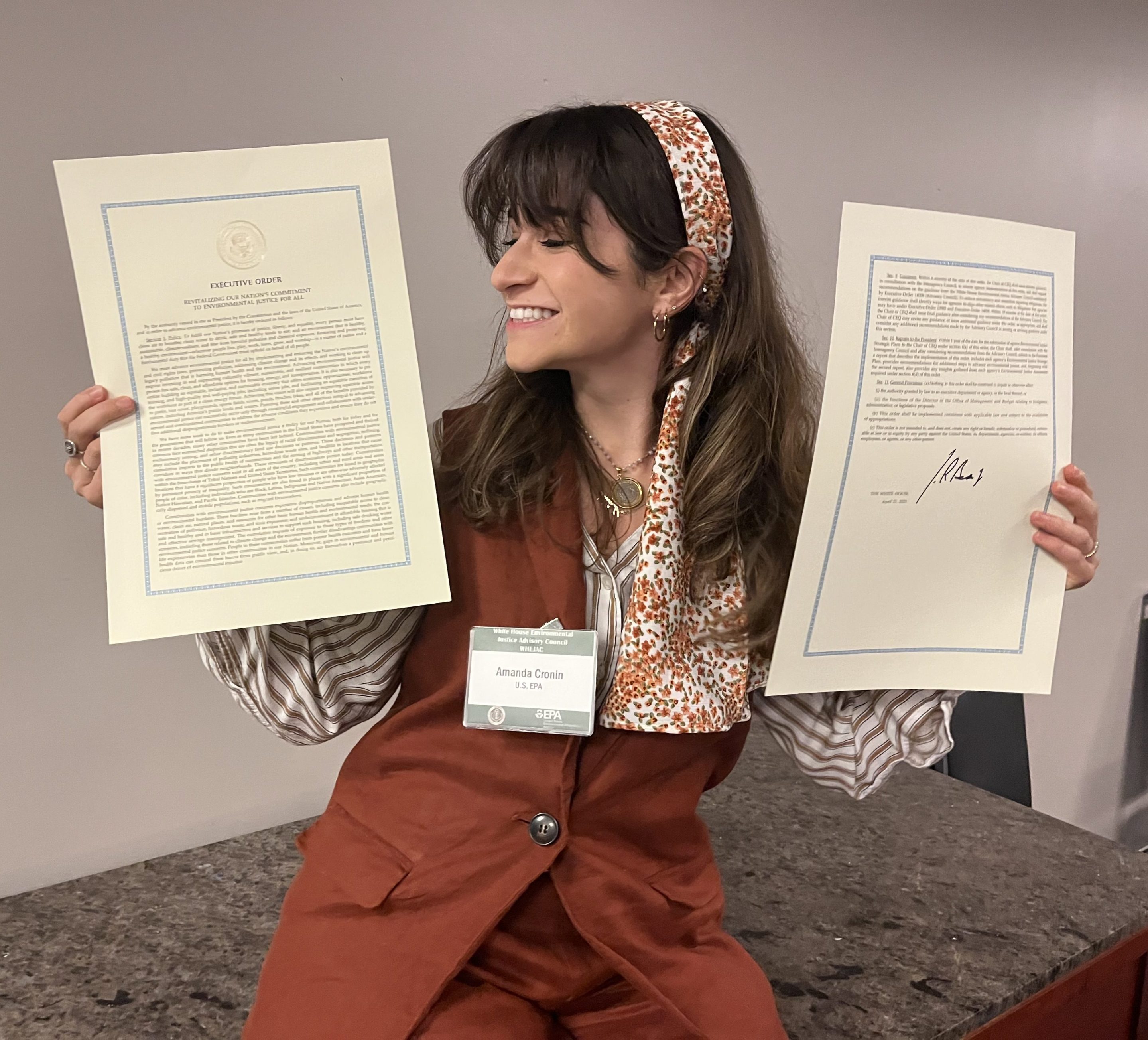 A photo of fired EPA program analyst Amanda Cronin holding the text of Executive Order 14096