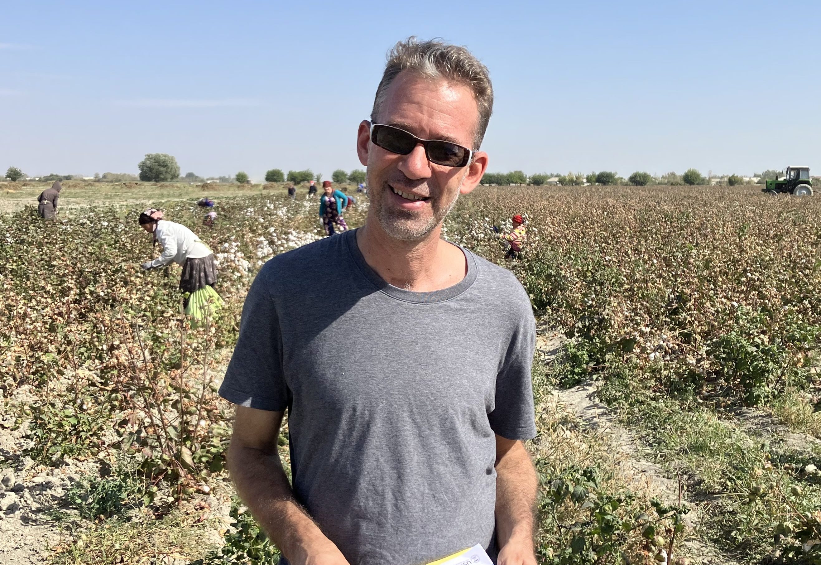A photo of a USAID education officer, Joel Runnels, standing in a field