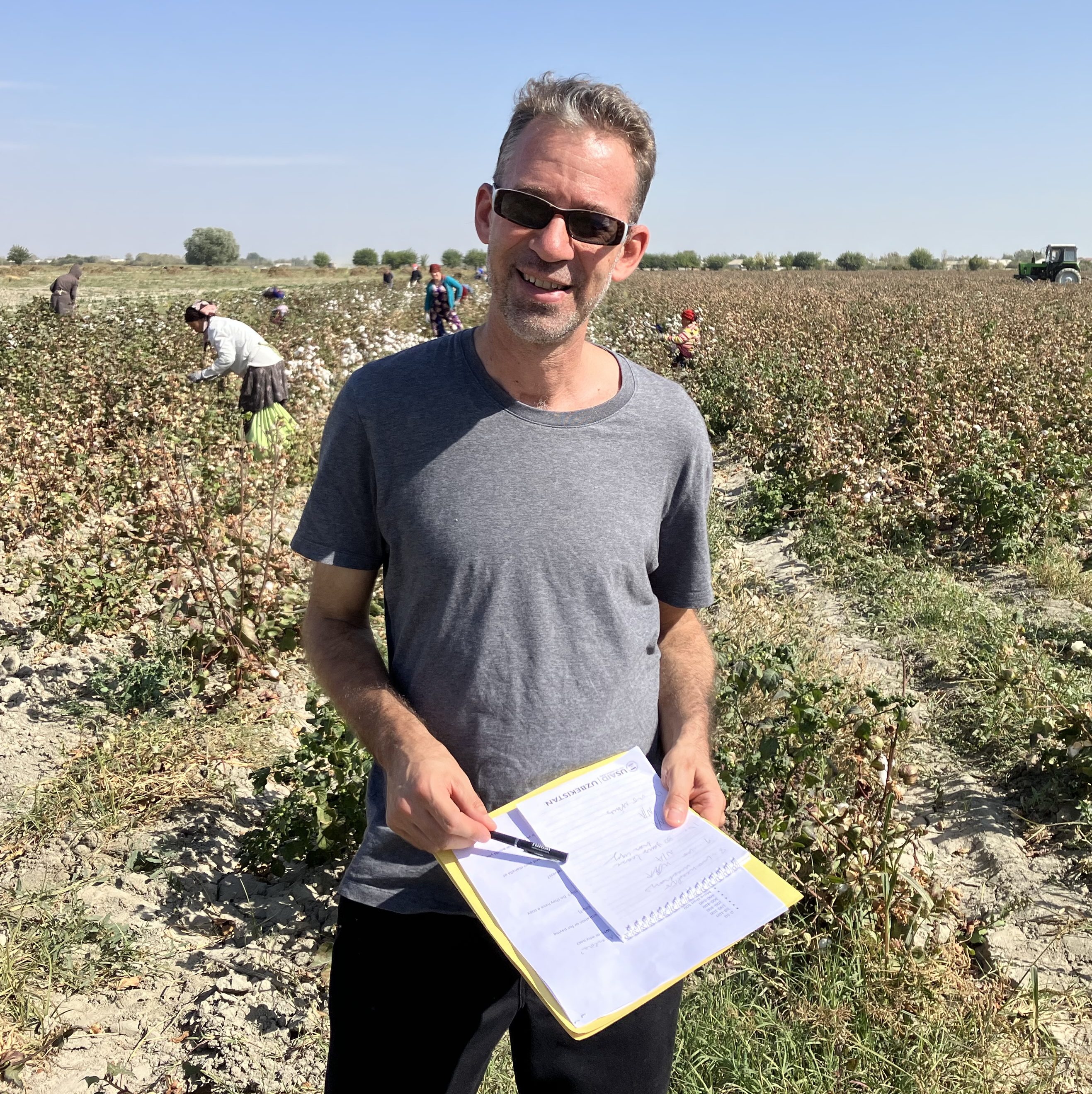 A photo of a USAID education officer, Joel Runnels, standing in a field