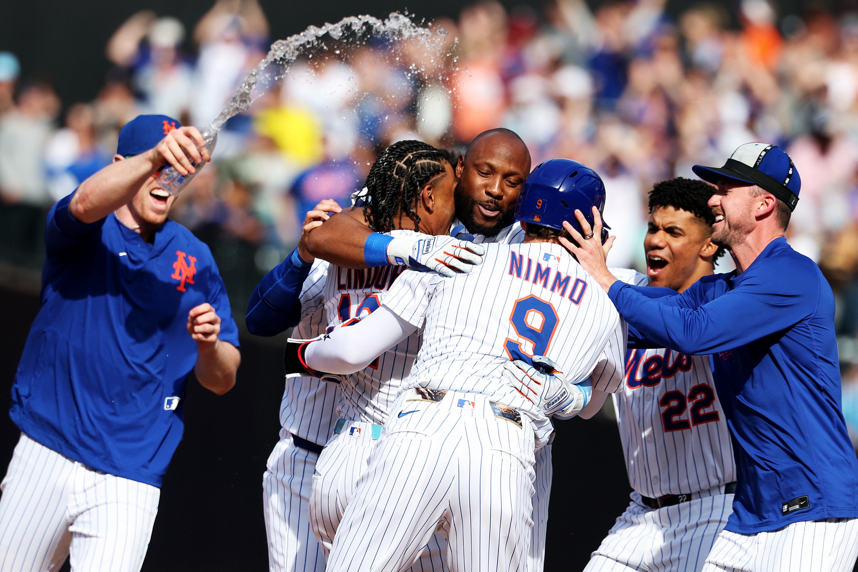 Starling Marte #6 of the New York Mets celebrates with his team after driving in the winning run.