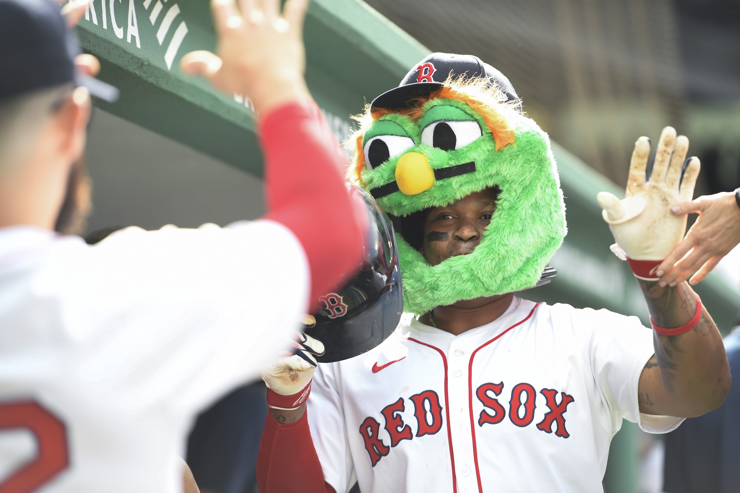 Rafeal Devers wears a green Wally mask in the dugout.