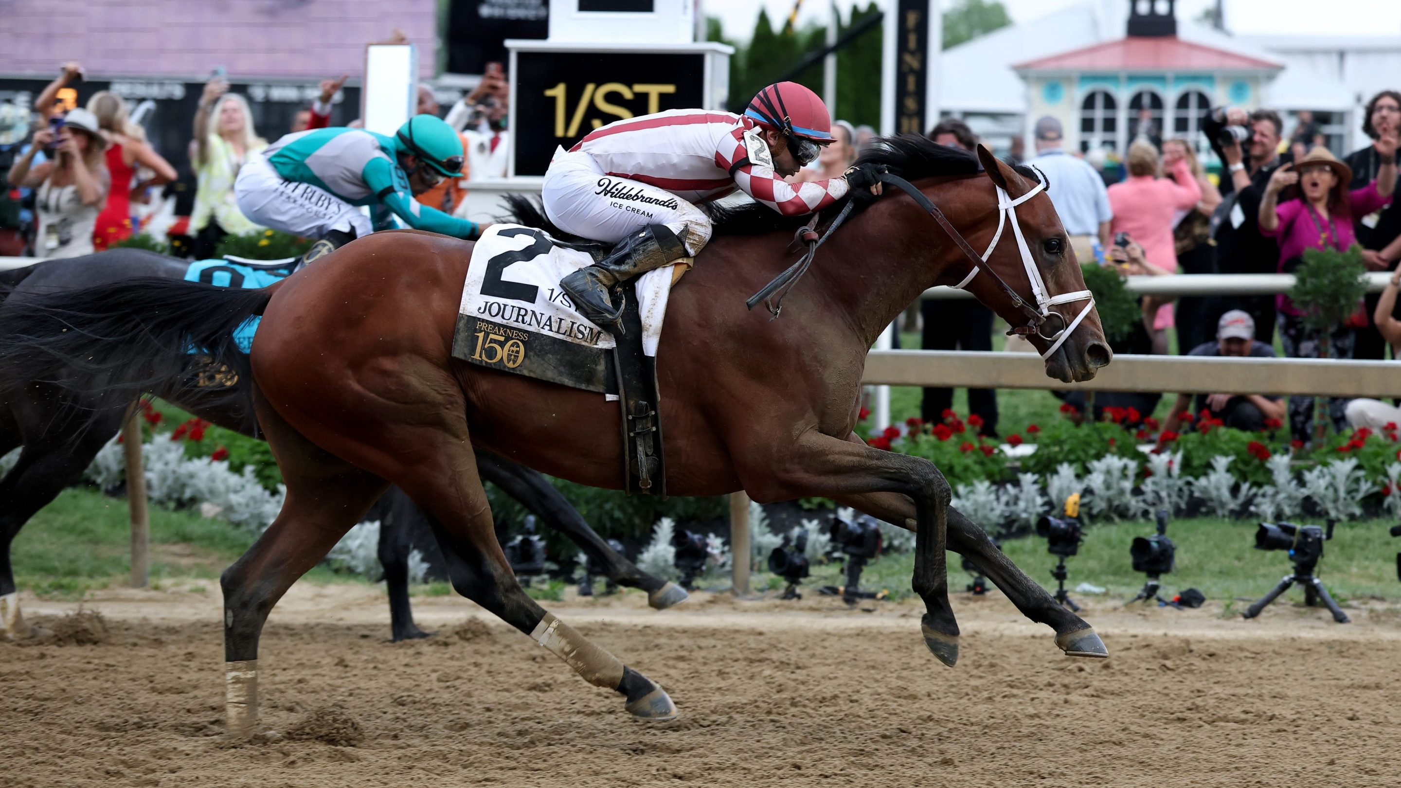 Jockey Umberto Rispoli crosses the finish line on Journalism #2 to ahead of jockey Luis Saez and Gosger #9 win the 150th Preakness Stakes at Pimlico Race Course on May 17, 2025 in Baltimore, Maryland.