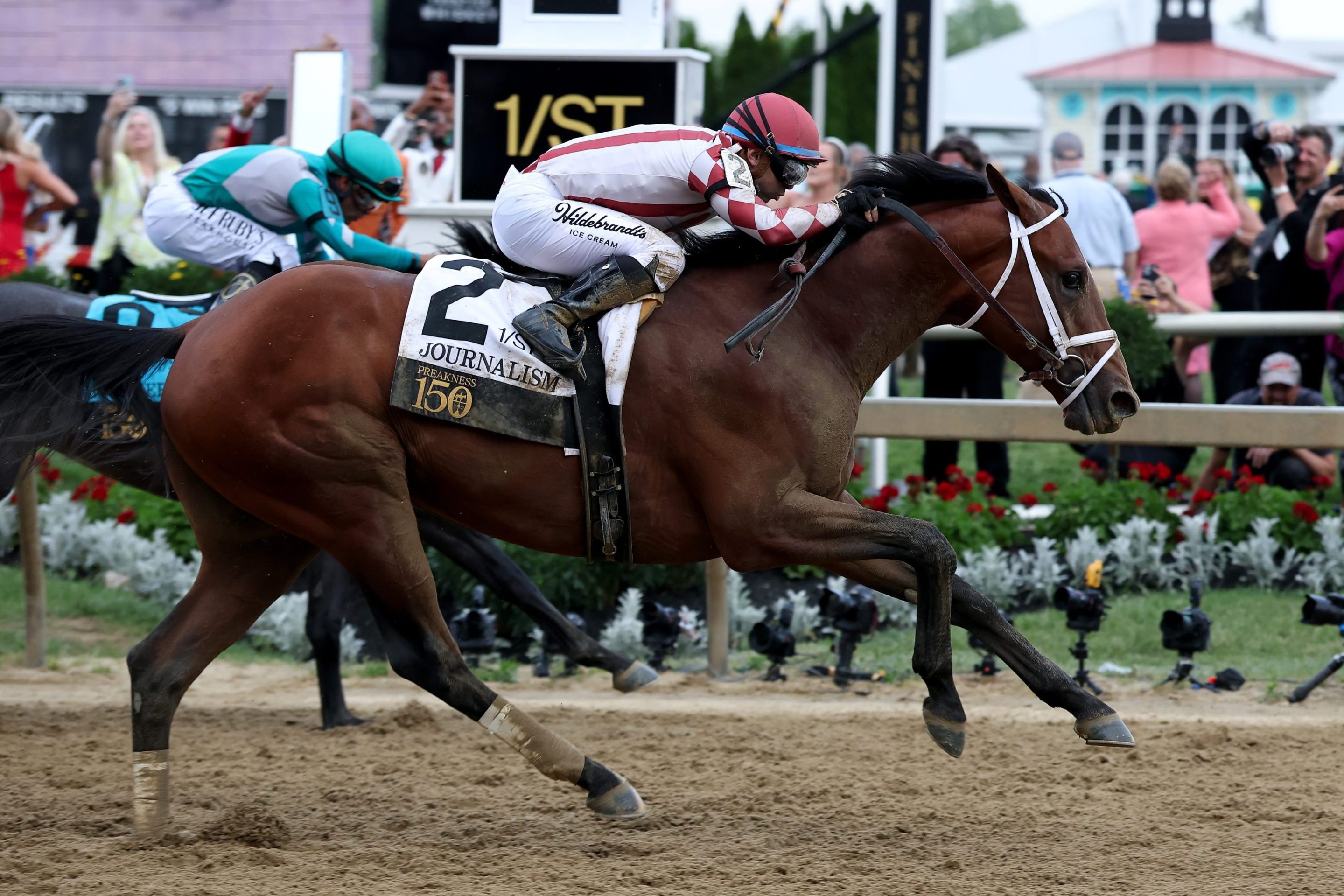 Jockey Umberto Rispoli crosses the finish line on Journalism #2 to ahead of jockey Luis Saez and Gosger #9 win the 150th Preakness Stakes at Pimlico Race Course on May 17, 2025 in Baltimore, Maryland.