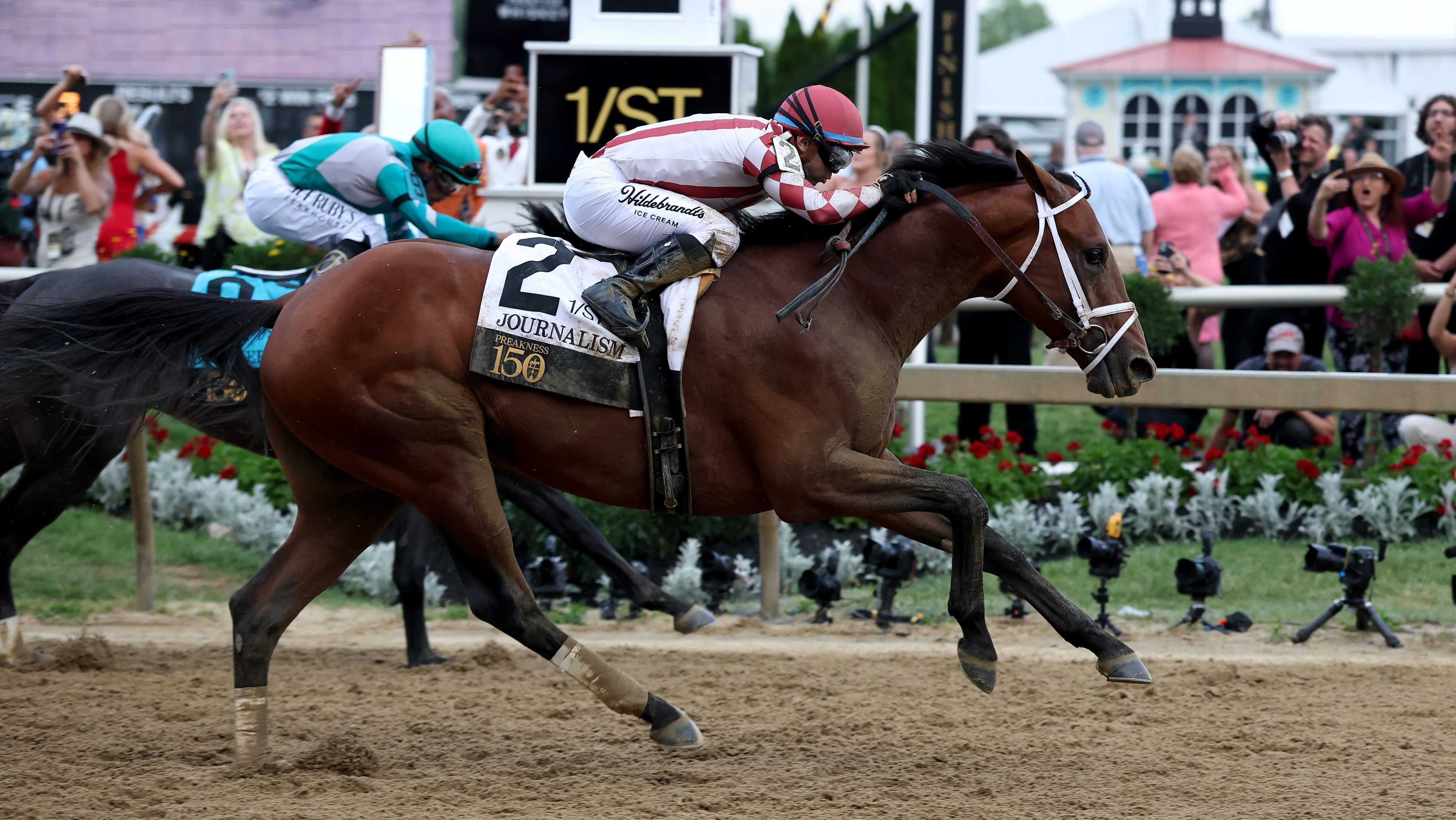 Jockey Umberto Rispoli crosses the finish line on Journalism #2 to ahead of jockey Luis Saez and Gosger #9 win the 150th Preakness Stakes at Pimlico Race Course on May 17, 2025 in Baltimore, Maryland.