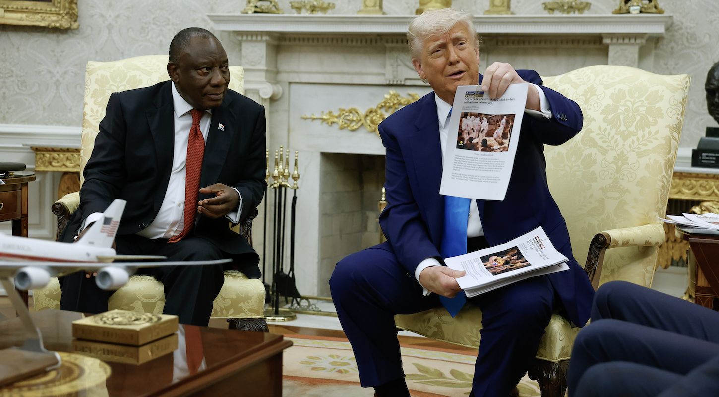 Donald Trump holds up a printed article from "American Thinker" while accusing South Africa President Cyril Ramaphosa of state-sanctioned violence against white farmers in South Africa during a press availability in the Oval Office at the White House on May 21, 2025 in Washington, DC.