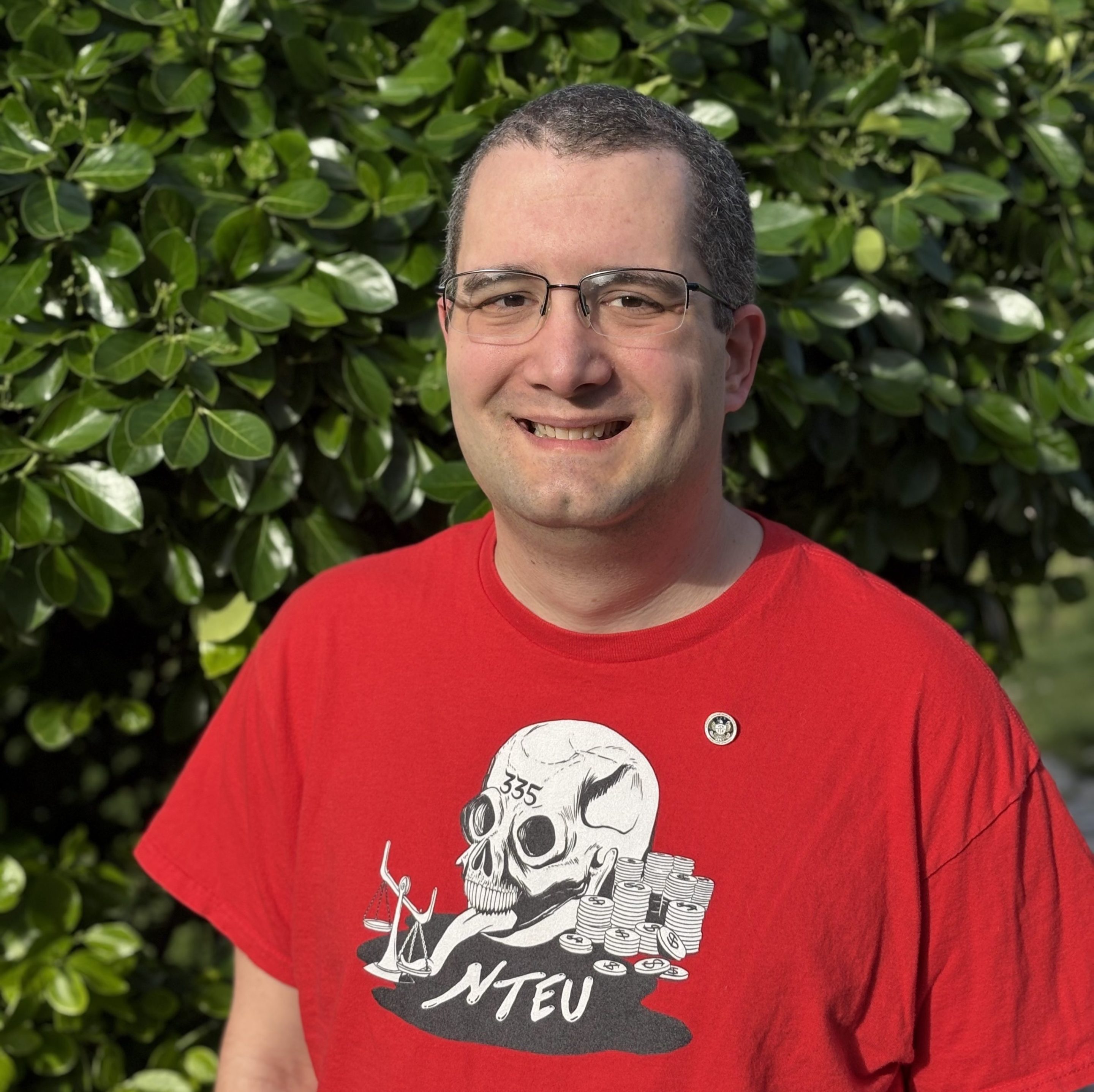a photo of Chuck Sebian-Lander, a fired CFPB web manager. He is wearing a a shirt from my union, NTEU 335, and b) a lapel pin with the CFPB seal that he was given as part of a Director's award