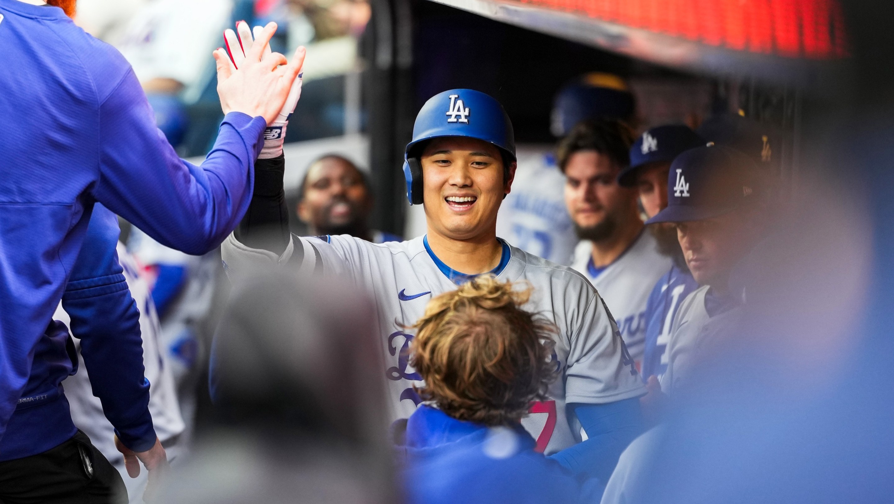 Shohei Ohtani #17 of the Los Angeles Dodgers celebrates with teammates in the dugout.