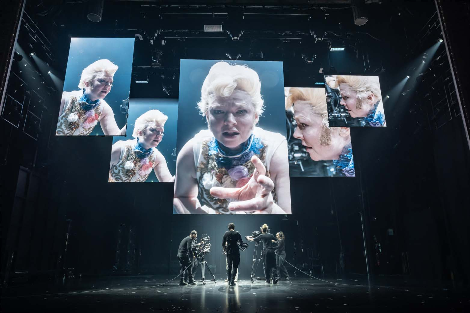 sarah snook on stage with several screens showing her
