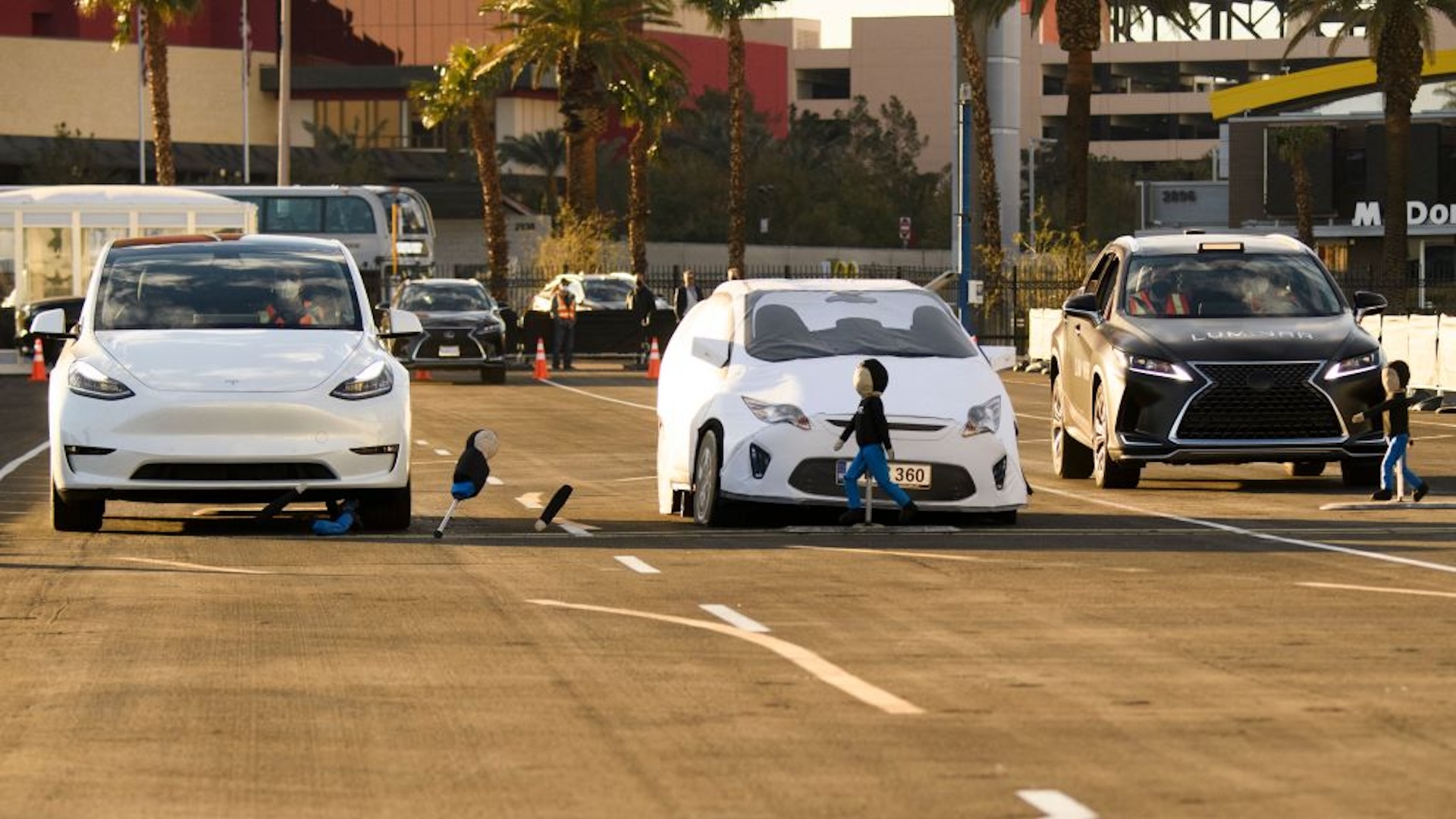 This photo taken on January 4, 2022 shows a vehicle with Luminar LiDAR based Proactive Safety pre-collision braking crash avoidance technology (R) stopping to avoid a child-sized test dummy as it is demonstrated on a test track, while a Tesla Model Y collides with the test dummy (L) at the Las Vegas Convention Center ahead of the Consumer Electronics Show (CES) in Las Vegas, Nevada. - As it pursues the goal of fully autonomous driving, Tesla has bet entirely on cameras and artificial intelligence, shunning other commonly used tools such as laser detection.