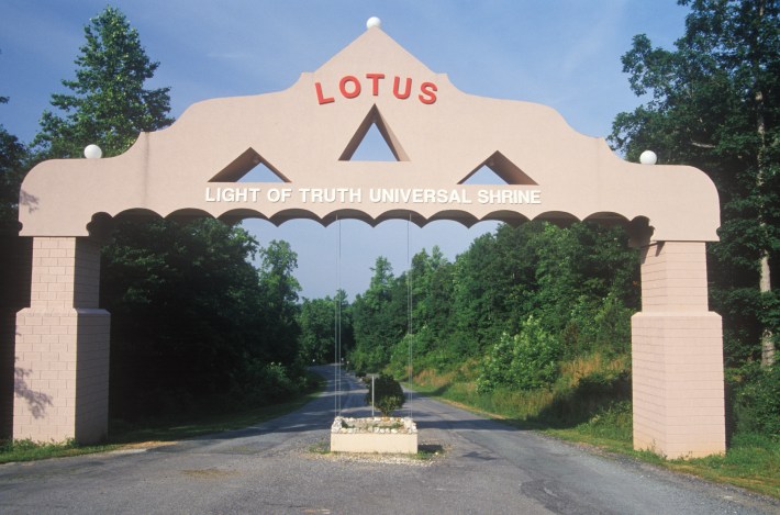 The arch way to the Satchidananda Ashram-Yogaville and Lotus Conference Center in, Buckingham Virginia. The top of the sign says "LOTUS." Below it reads, "Light of truth universal shrine."