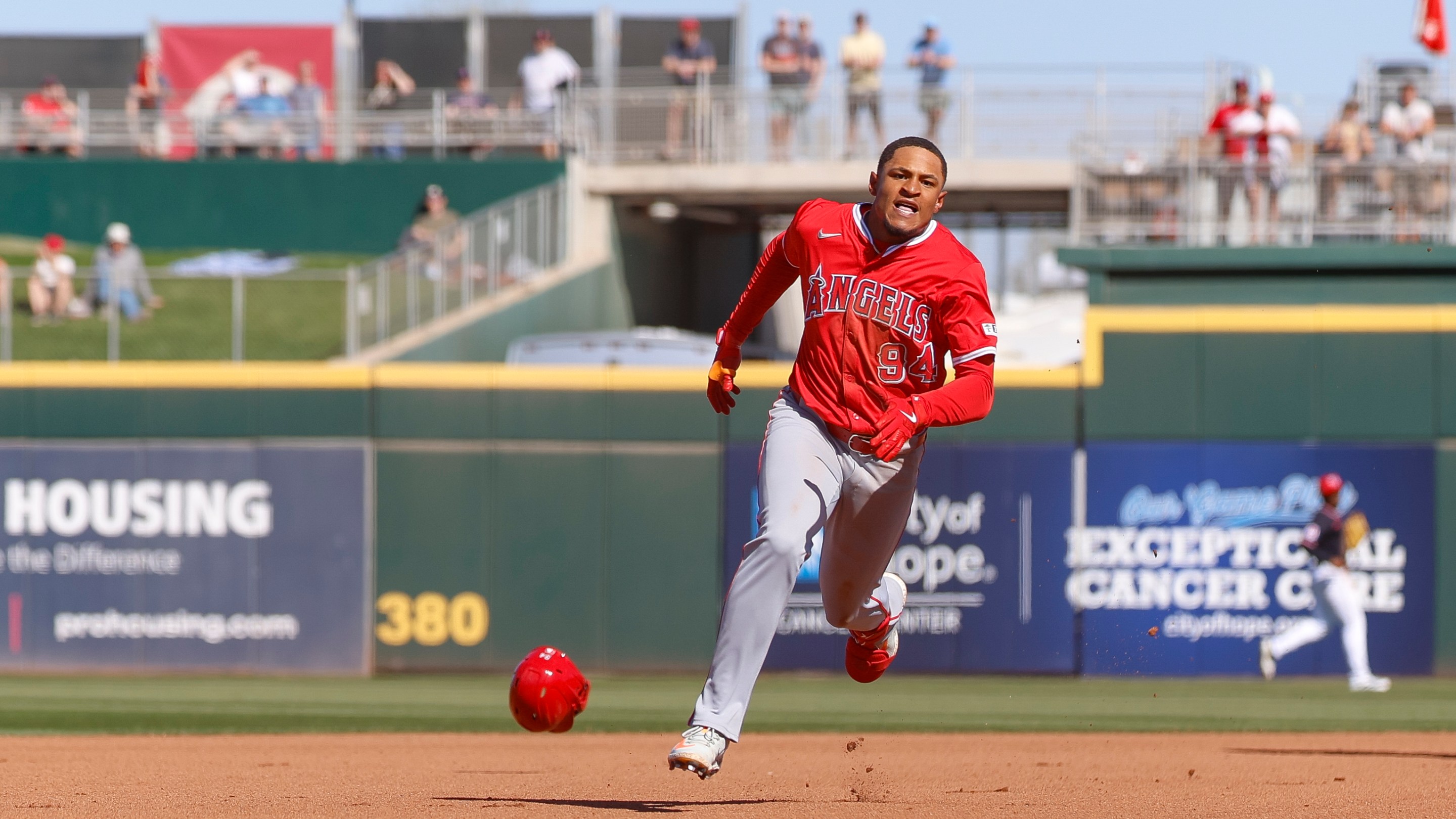 Christian Moore #94 of the Los Angeles Angels loses his helmet running to third base