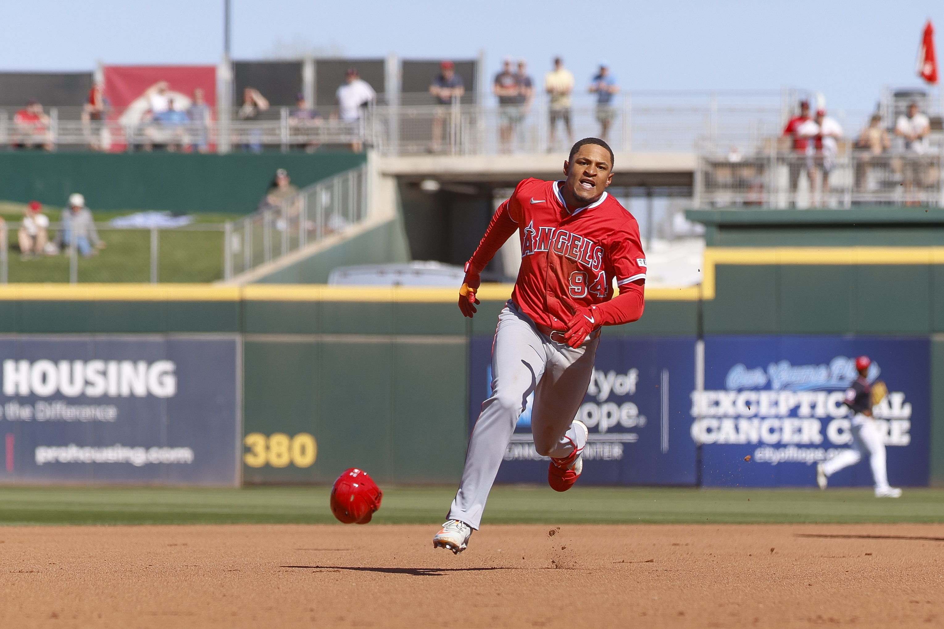 Christian Moore #94 of the Los Angeles Angels loses his helmet running to third base