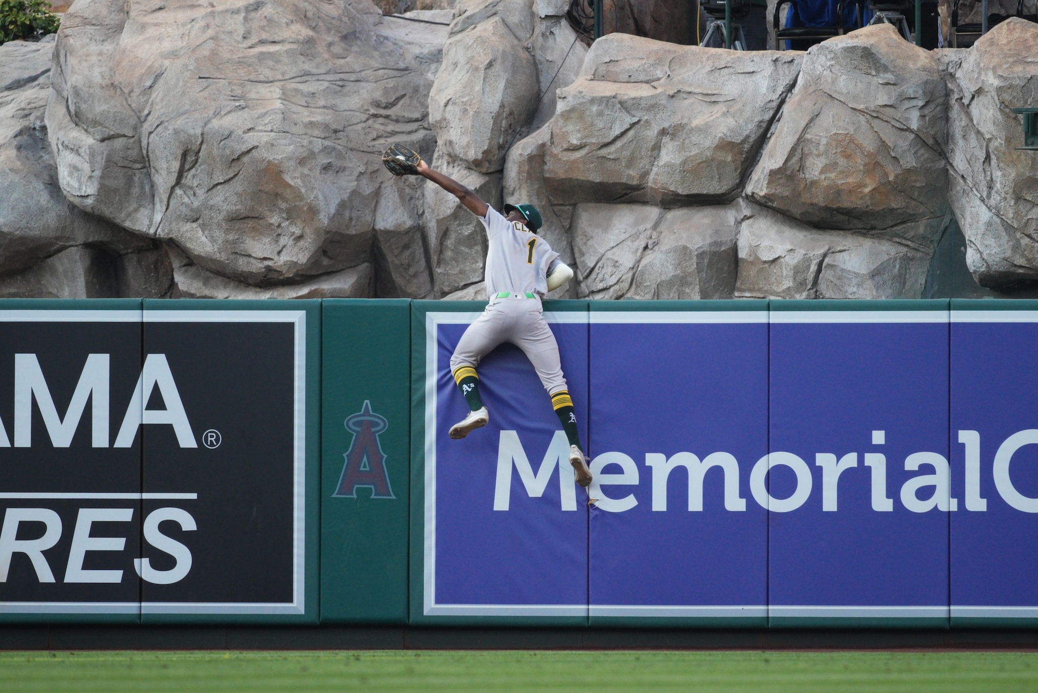Denzel Clarke of the Athletics makes an amazing catch and nearly vaults over the wall during the game between the Athletics and the Los Angeles Angels at Angel Stadium of Anaheim on Monday, June 9, 2025.