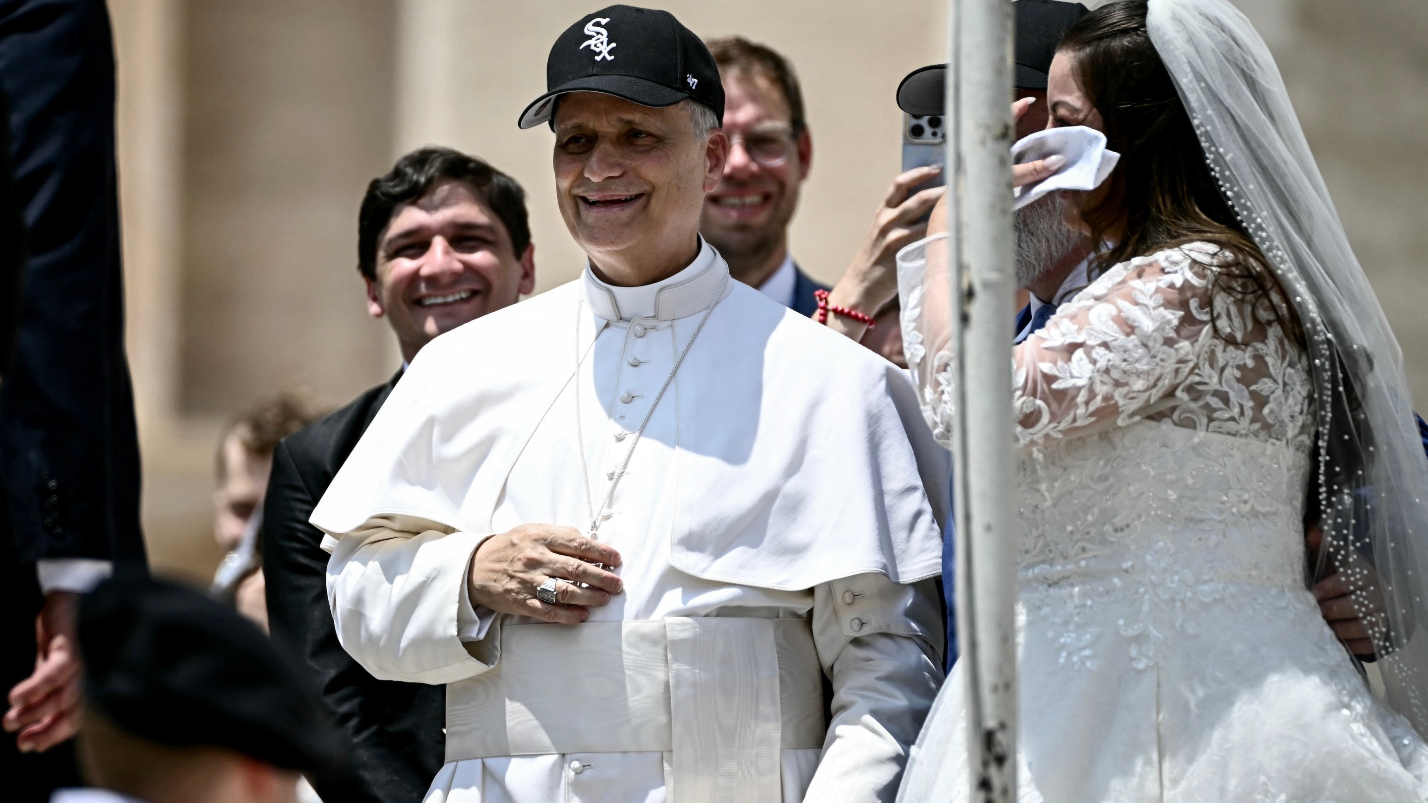 Pope Leo XIV (C) reacts wearing a Chicago White Sox baseball team cap as he meets newly wedded couples during the weekly general audience in St Peter's Square at the Vatican on June 11, 2025. (Photo by Filippo MONTEFORTE / AFP)