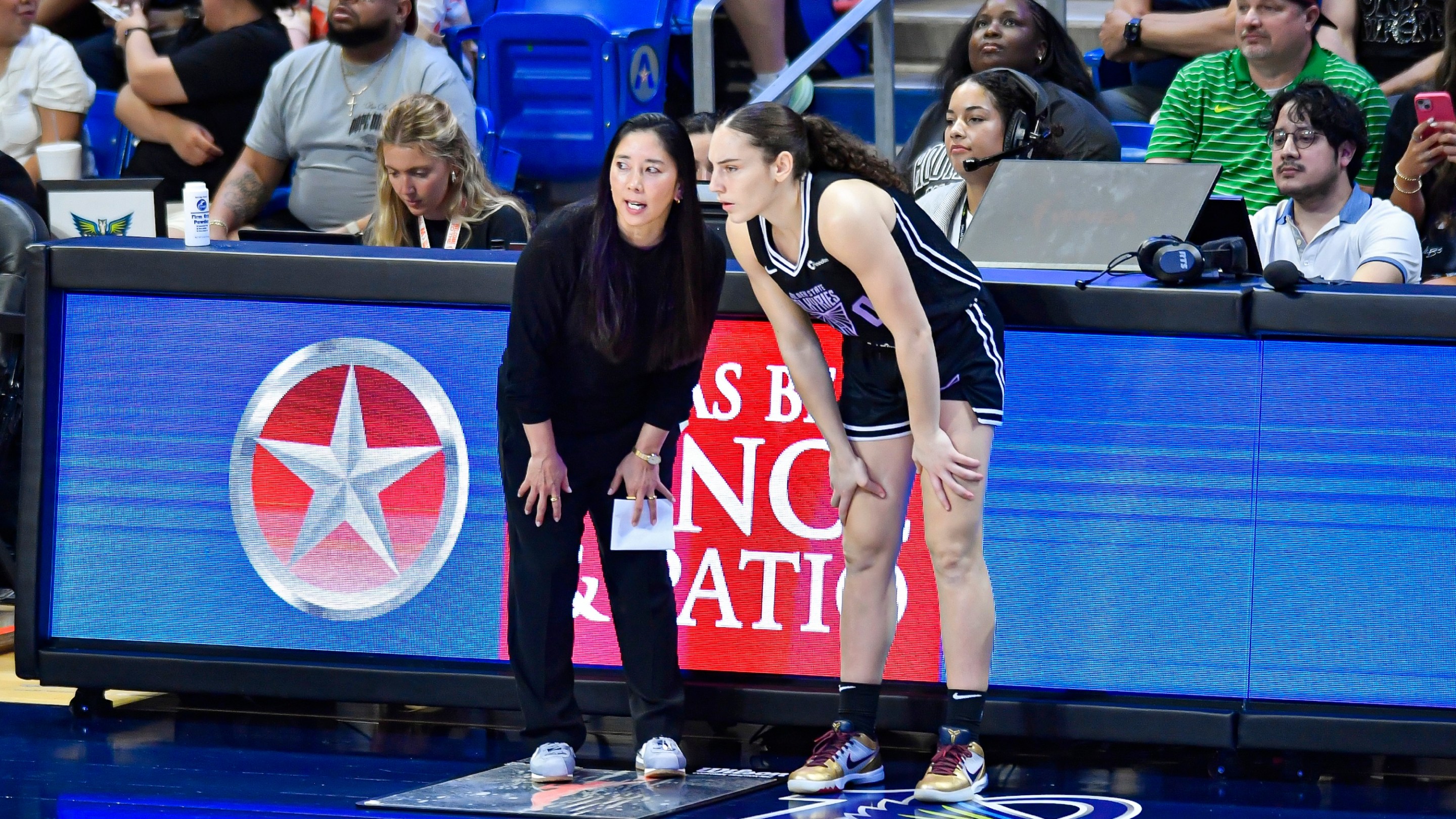 Golden State Valkyries coach Natalie Nakase (left) talks with guard Carla Leite (right) during the second quarter of a WNBA game between the Golden State Valkyries and Dallas Wings on Tuesday, June 17, 2025 at College Park Center in Arlington, TX.