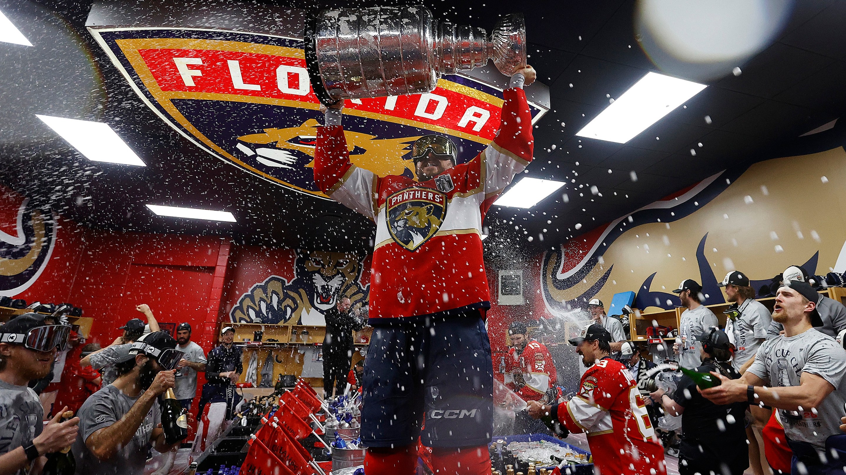 SUNRISE, FLORIDA - JUNE17: Sam Reinhart #13 of the Florida Panthers lifts the cup in the locker room during their team celebration after beating the Edmonton Oilers in Game Six of the 2025 Stanley Cup Final at the Amerant Bank Arena on June 17, 2025 in Sunrise, Florida. (Photo by Eliot J. Schechter/NHLI via Getty Images)