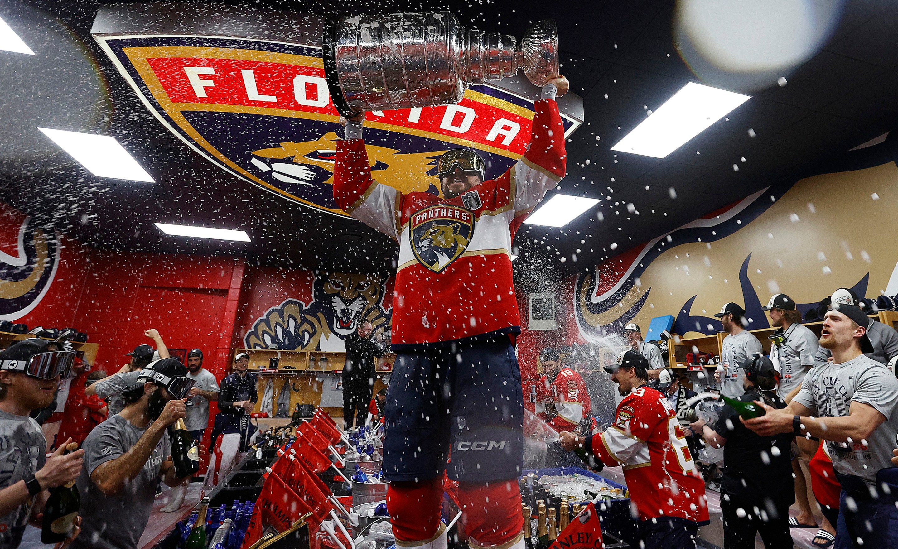 SUNRISE, FLORIDA - JUNE17: Sam Reinhart #13 of the Florida Panthers lifts the cup in the locker room during their team celebration after beating the Edmonton Oilers in Game Six of the 2025 Stanley Cup Final at the Amerant Bank Arena on June 17, 2025 in Sunrise, Florida. (Photo by Eliot J. Schechter/NHLI via Getty Images)