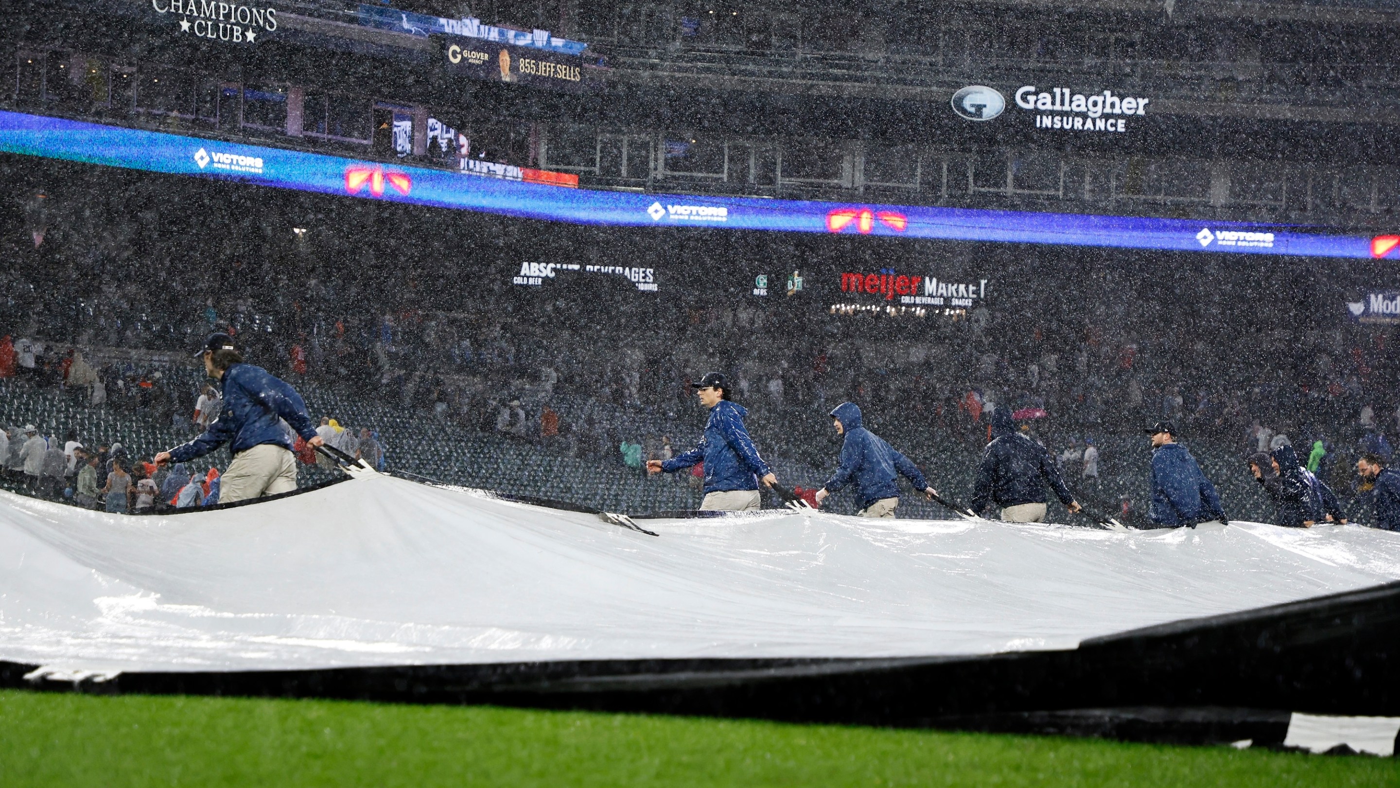 The grounds crew covers the field with a tarp during a thunderstorm in the bottom of the ninth inning of game two of a doubleheader that is tied at 4-4 between the Detroit Tigers and the Pittsburgh Pirates at Comerica Park on June 19, 2025 in Detroit, Michigan.