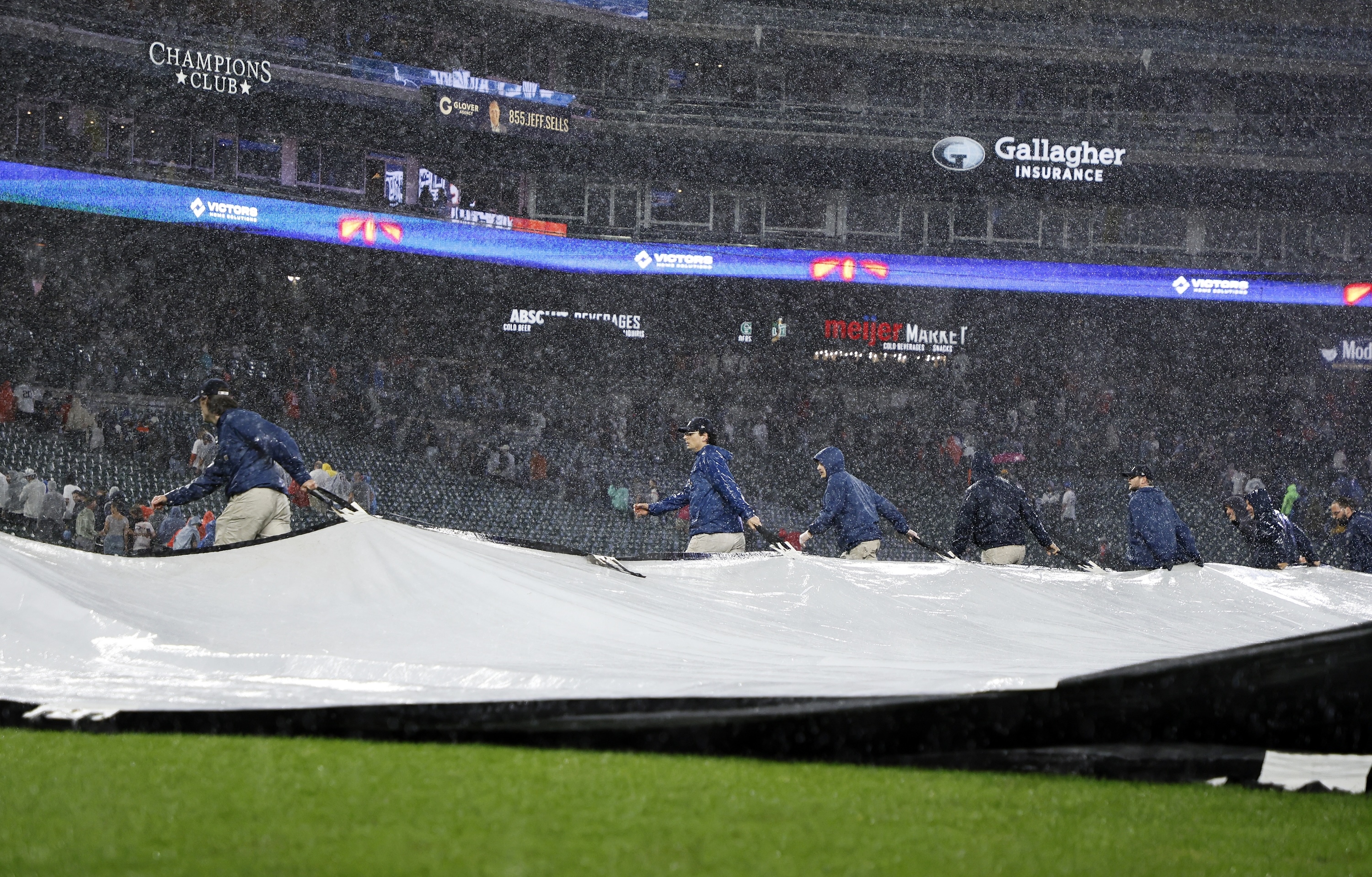 The grounds crew covers the field with a tarp during a thunderstorm in the bottom of the ninth inning of game two of a doubleheader that is tied at 4-4 between the Detroit Tigers and the Pittsburgh Pirates at Comerica Park on June 19, 2025 in Detroit, Michigan.