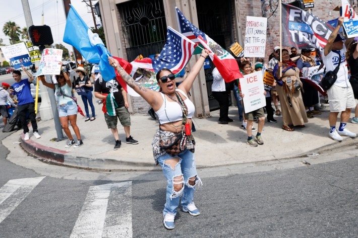 A woman dances on the street as people protest against the ongoing ICE raids in Los Angeles and the Dodgers on Sunset and Vin Scully Ave. on Saturday, June 21, 2025 in Los Angeles, CA.