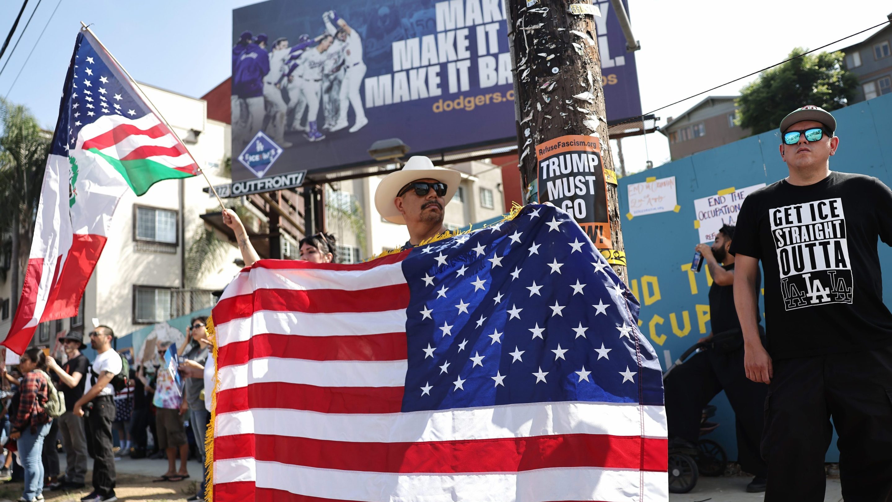 A protester holds a backwards American flag outside of Dodger Stadium during a protest against the Los Angeles Dodgers organization and ICE immigration raids on June 21, 2025 in Los Angeles, California.