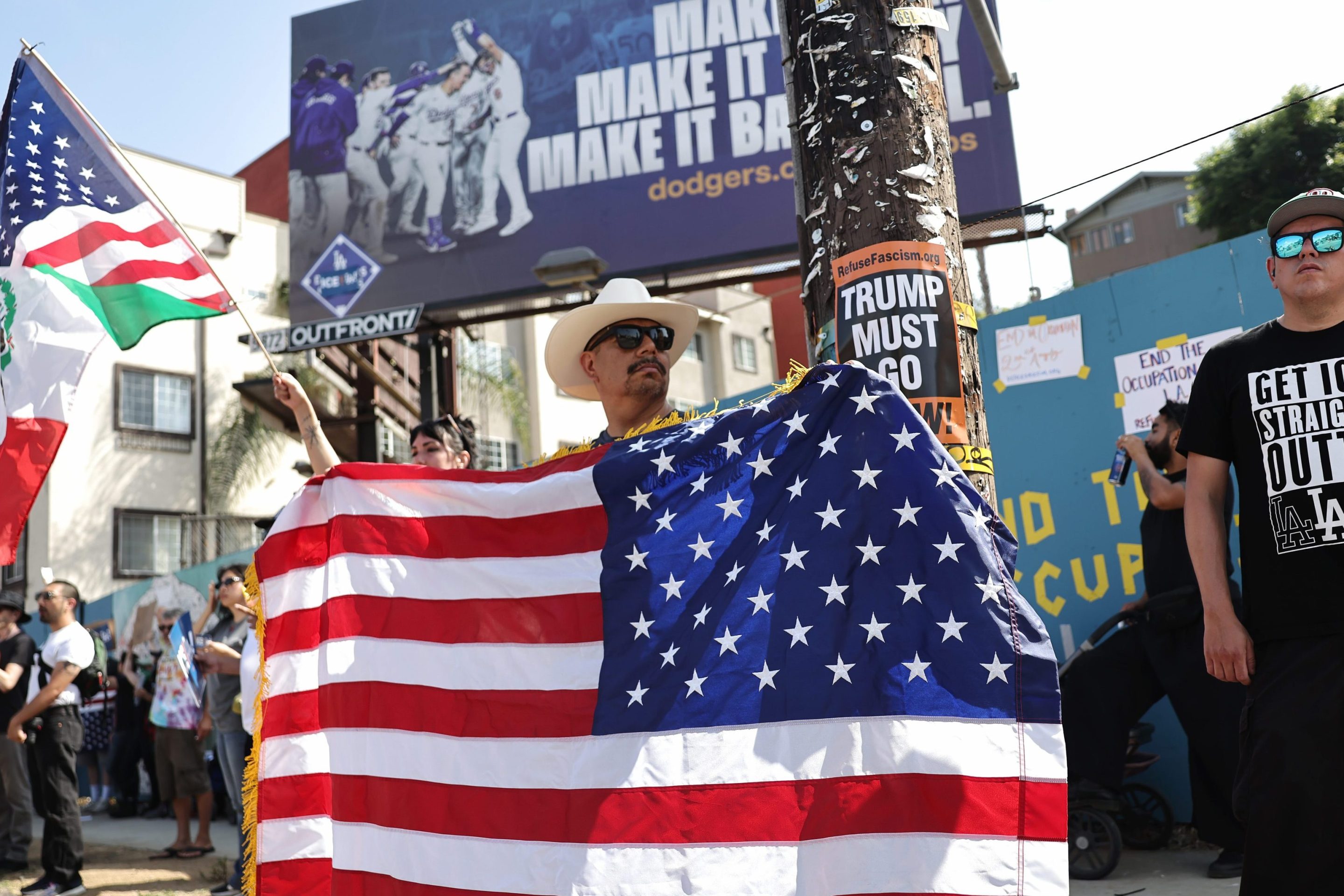 A protester holds a backwards American flag outside of Dodger Stadium during a protest against the Los Angeles Dodgers organization and ICE immigration raids on June 21, 2025 in Los Angeles, California.