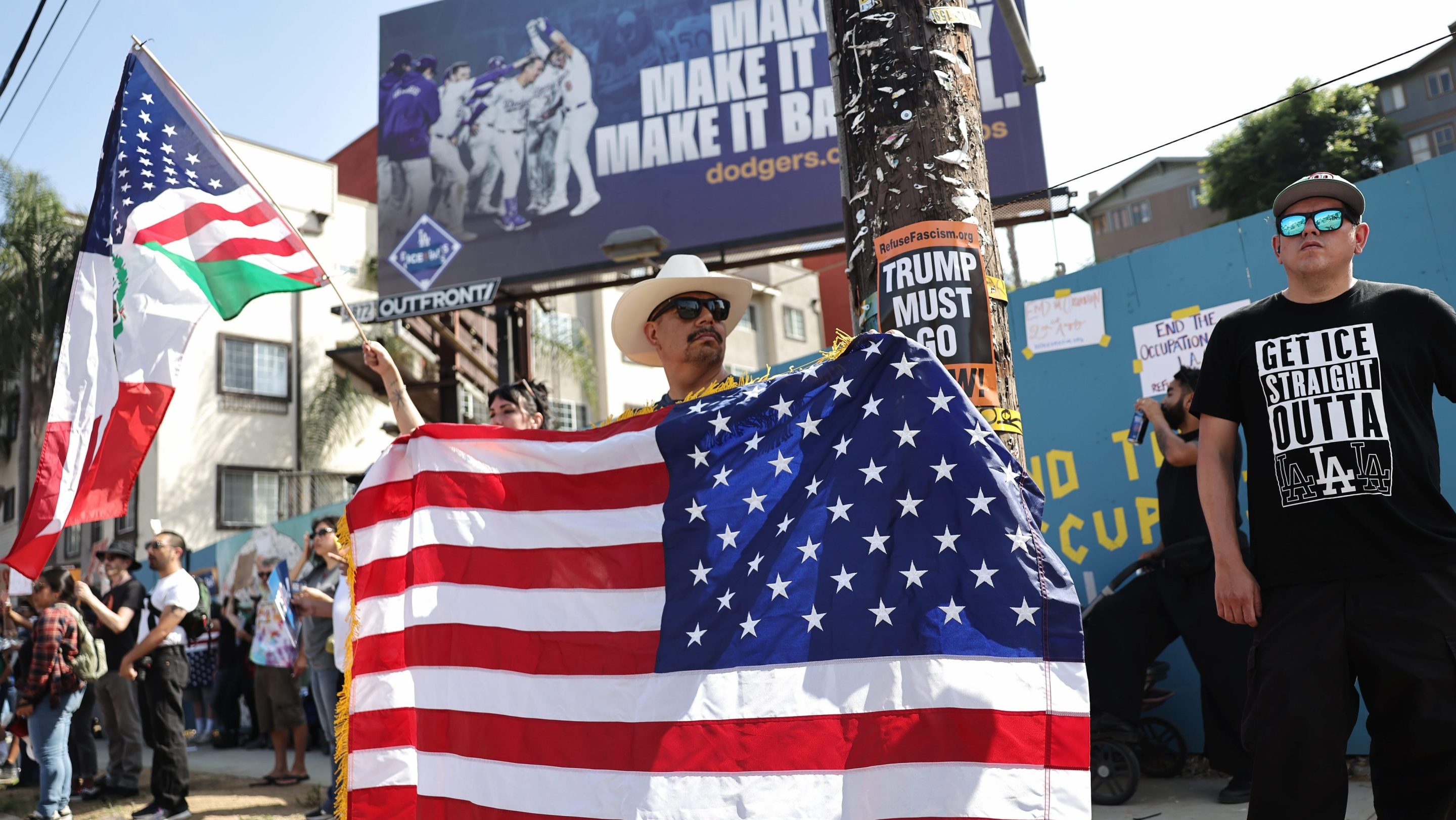 A protester holds a backwards American flag outside of Dodger Stadium during a protest against the Los Angeles Dodgers organization and ICE immigration raids on June 21, 2025 in Los Angeles, California.