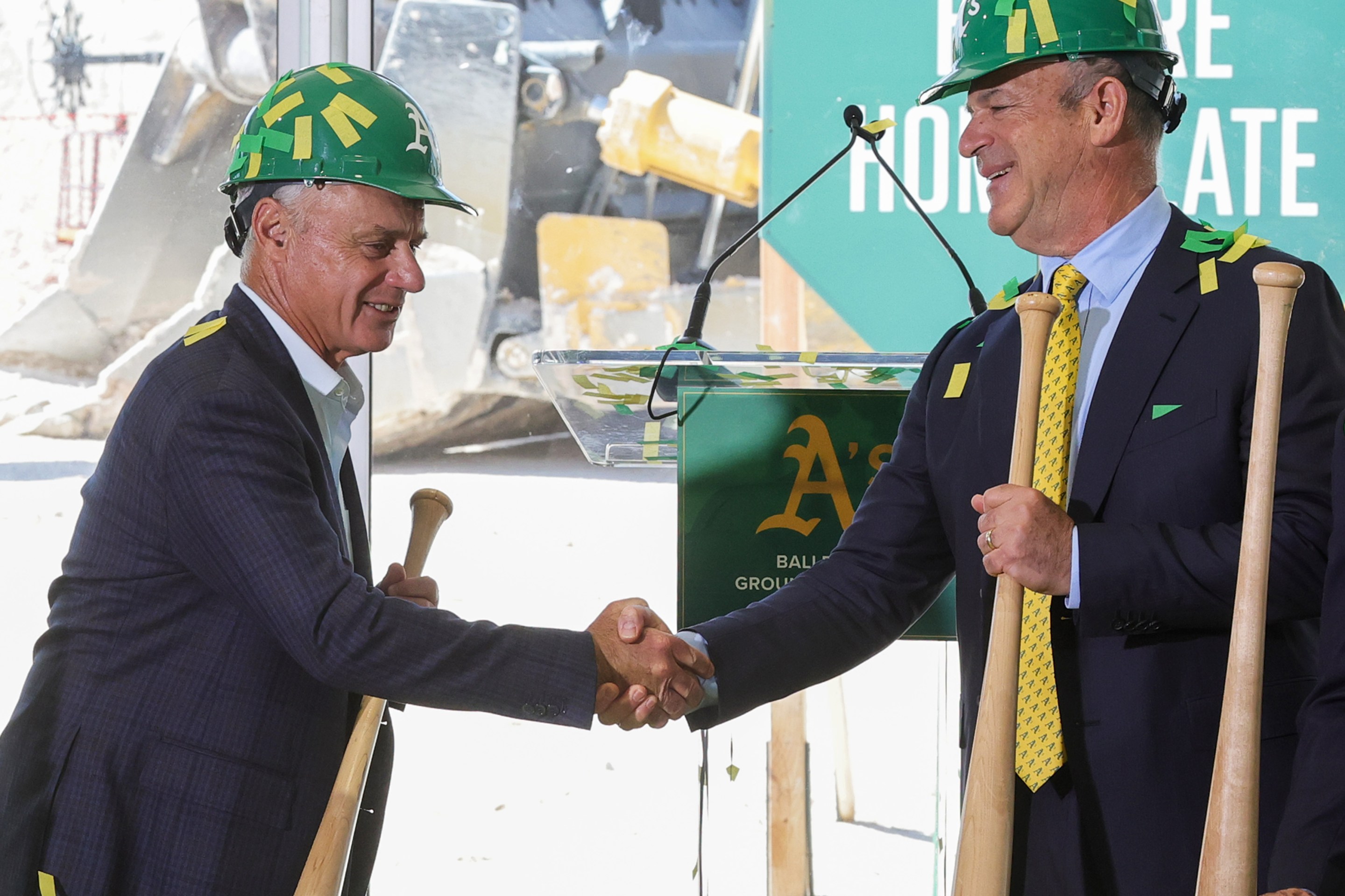 Major League Baseball Commissioner Rob Manfred (L) and principal owner John Fisher of the Athletics shake hands after participating in a ceremonial groundbreaking for the A's new stadium in Las Vegas.