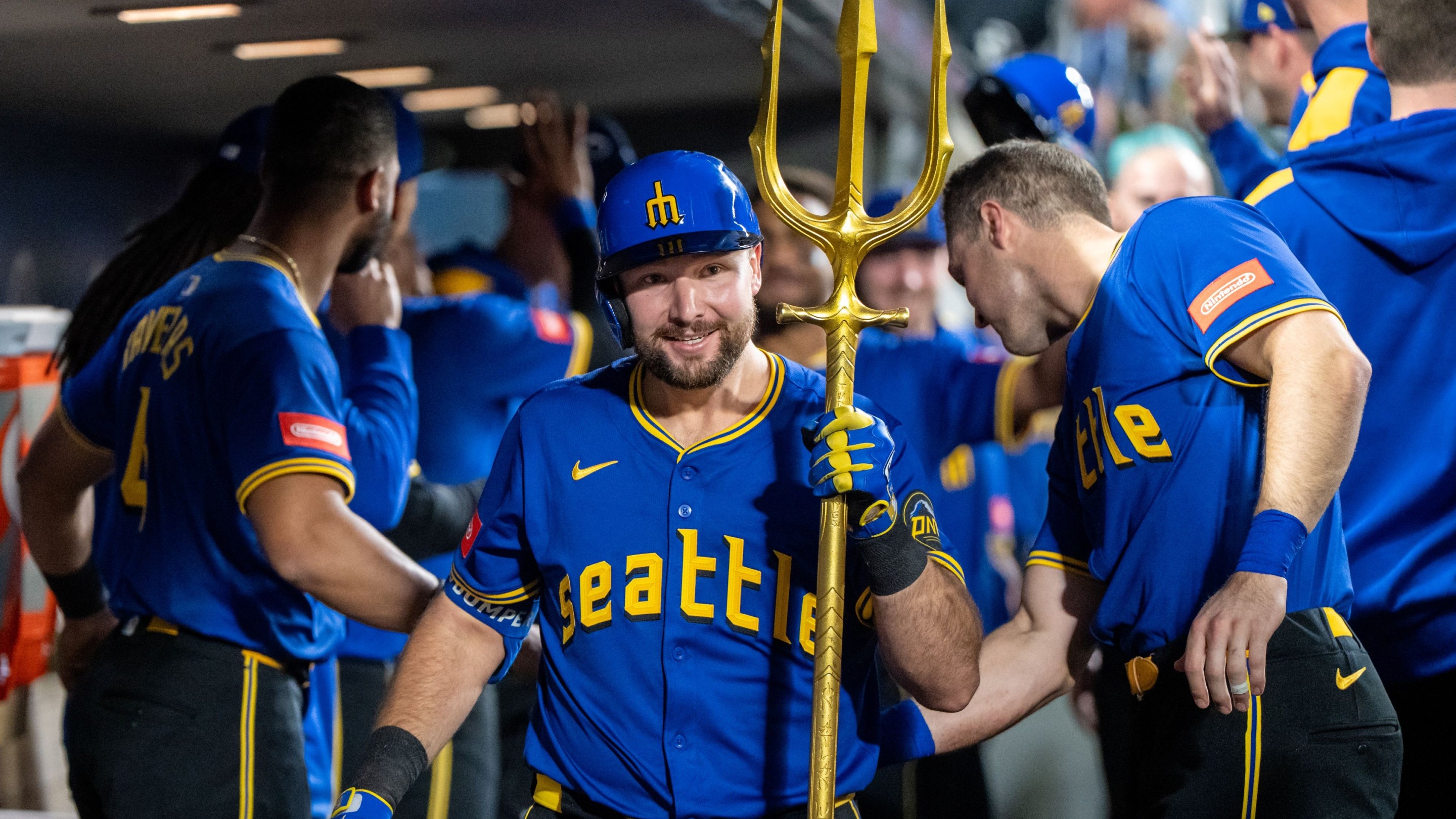 al Raleigh #29 of the Seattle Mariners celebrates in the dugout with a trident after hitting a home run.