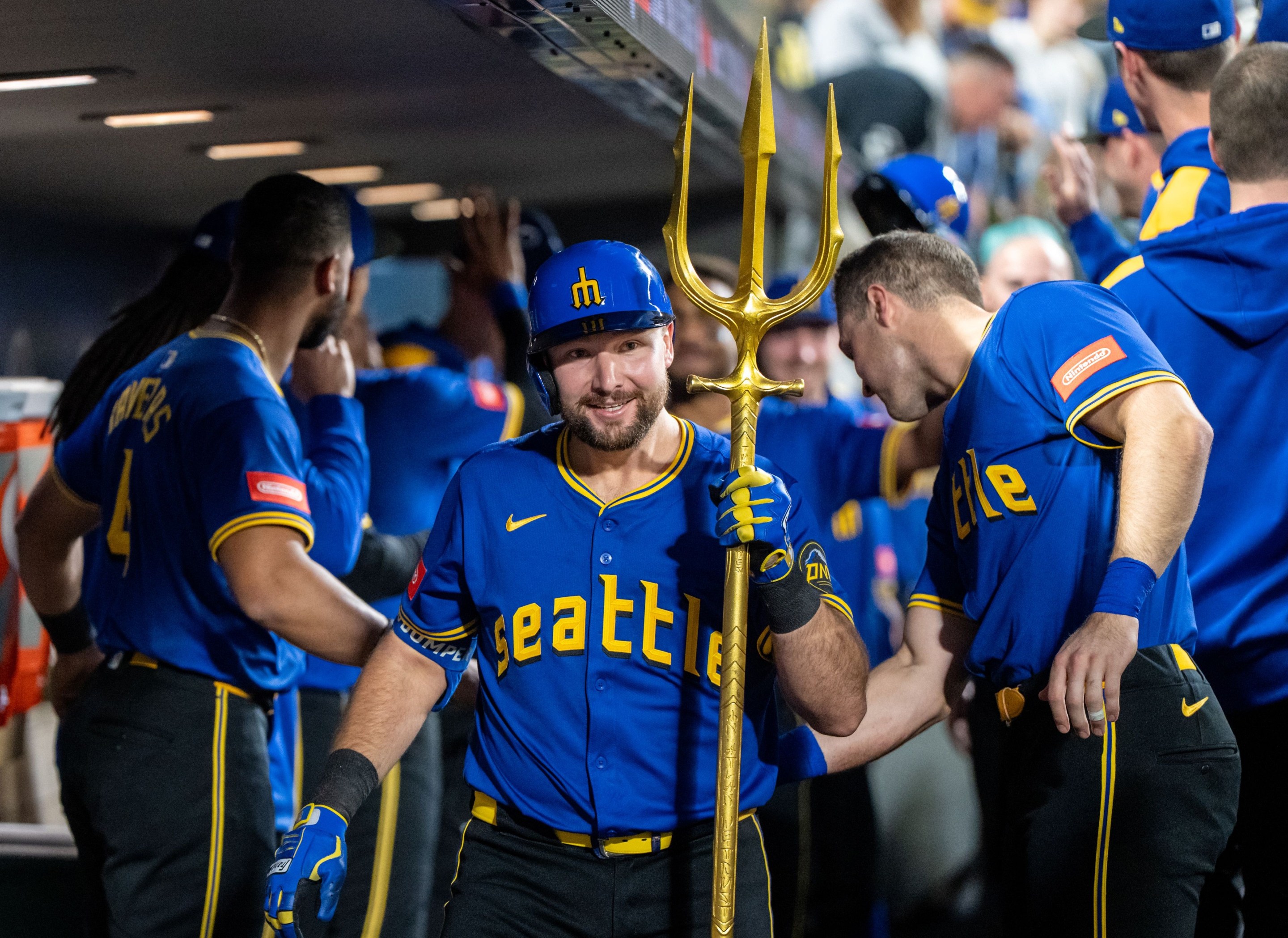 al Raleigh #29 of the Seattle Mariners celebrates in the dugout with a trident after hitting a home run.