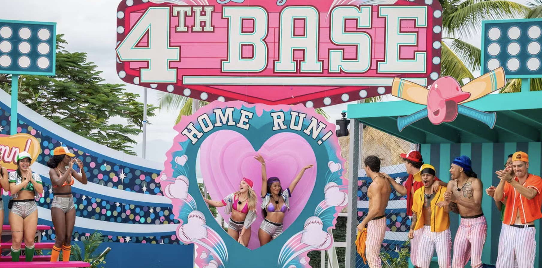two new bombshells stand inside a heart that says homerun underneath a sign that says 4th base.