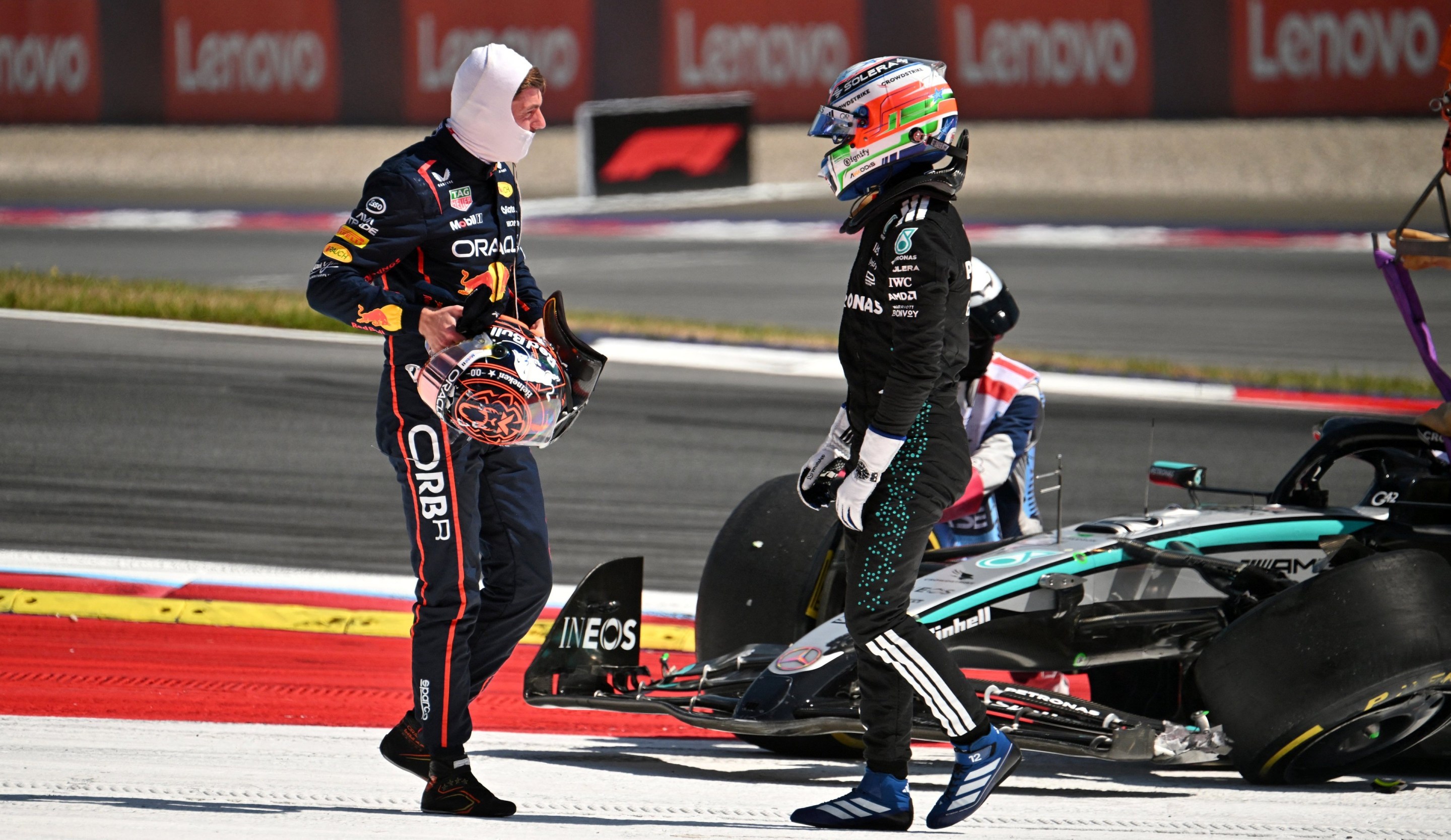 Red Bull's Dutch driver Max Verstappen (L) and Mercedes' Italian driver Kimi Antonelli speak after their cars crashed.