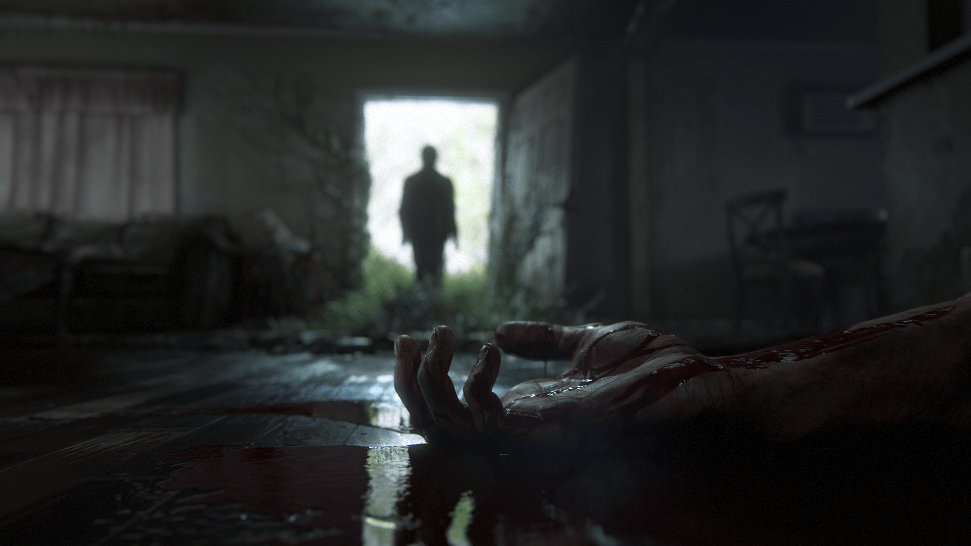 A bloody hand in the foreground while someone walks in through a door in 'The Last Of Us Part II'