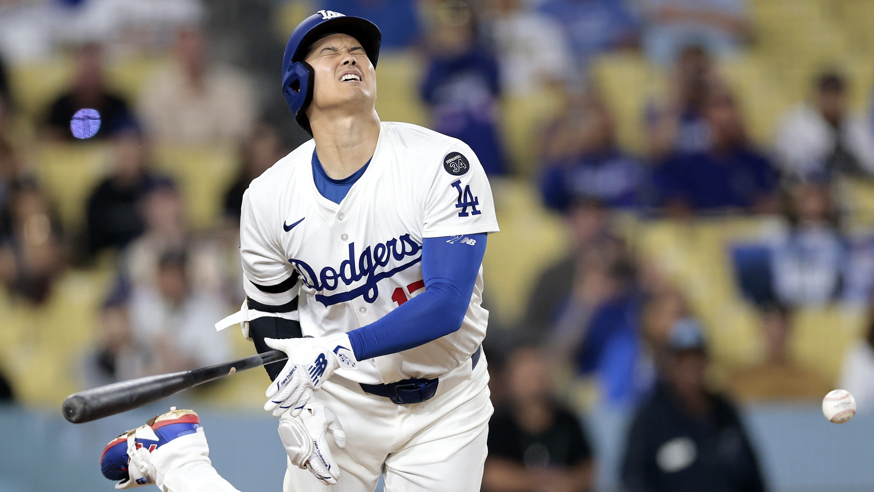 Shohei Ohtani #17 of the Los Angeles Dodgers is hit by a pitch from Robert Suarez #75 of the San Diego Padres in the ninth inning.