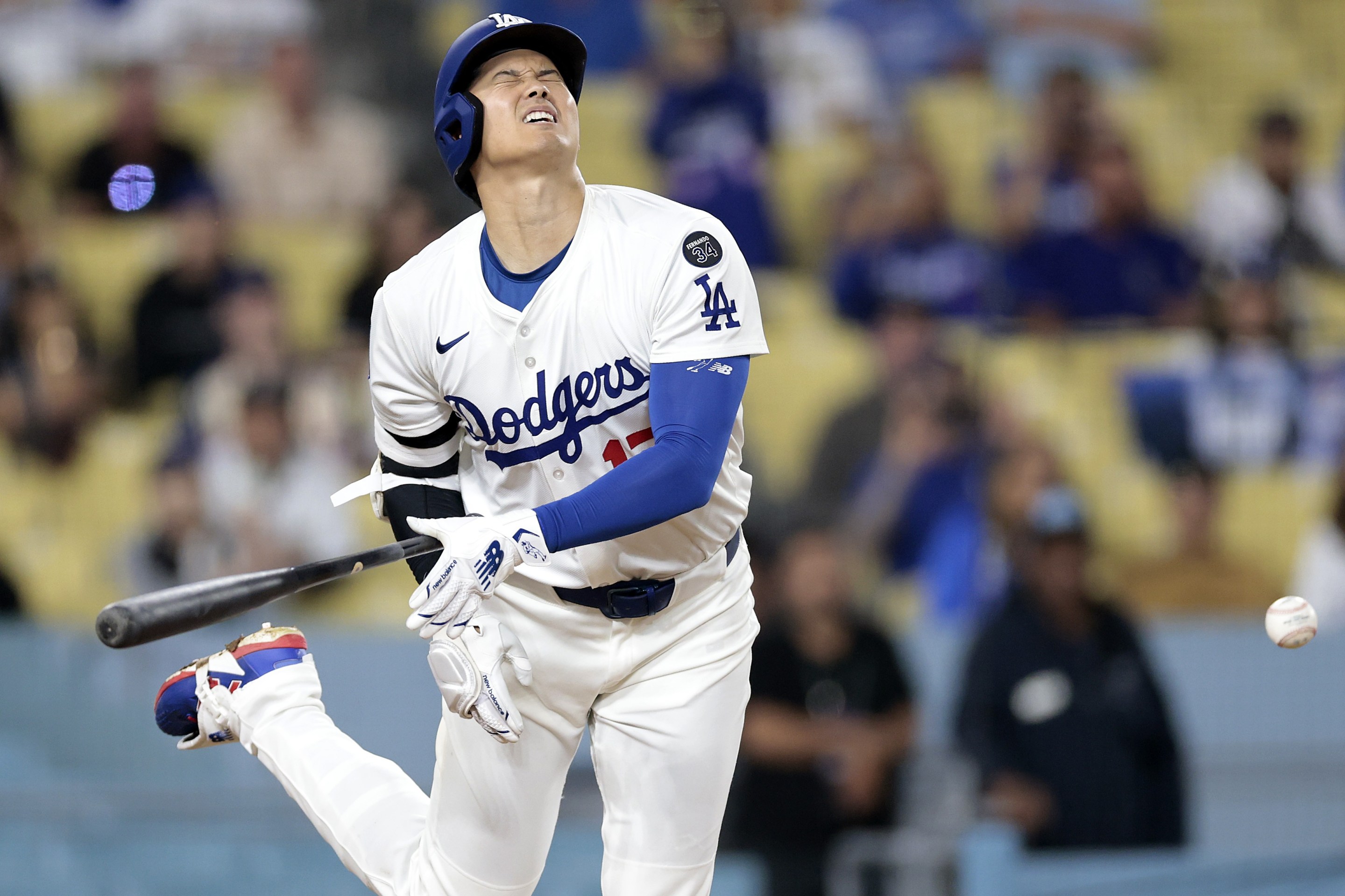 Shohei Ohtani #17 of the Los Angeles Dodgers is hit by a pitch from Robert Suarez #75 of the San Diego Padres in the ninth inning.